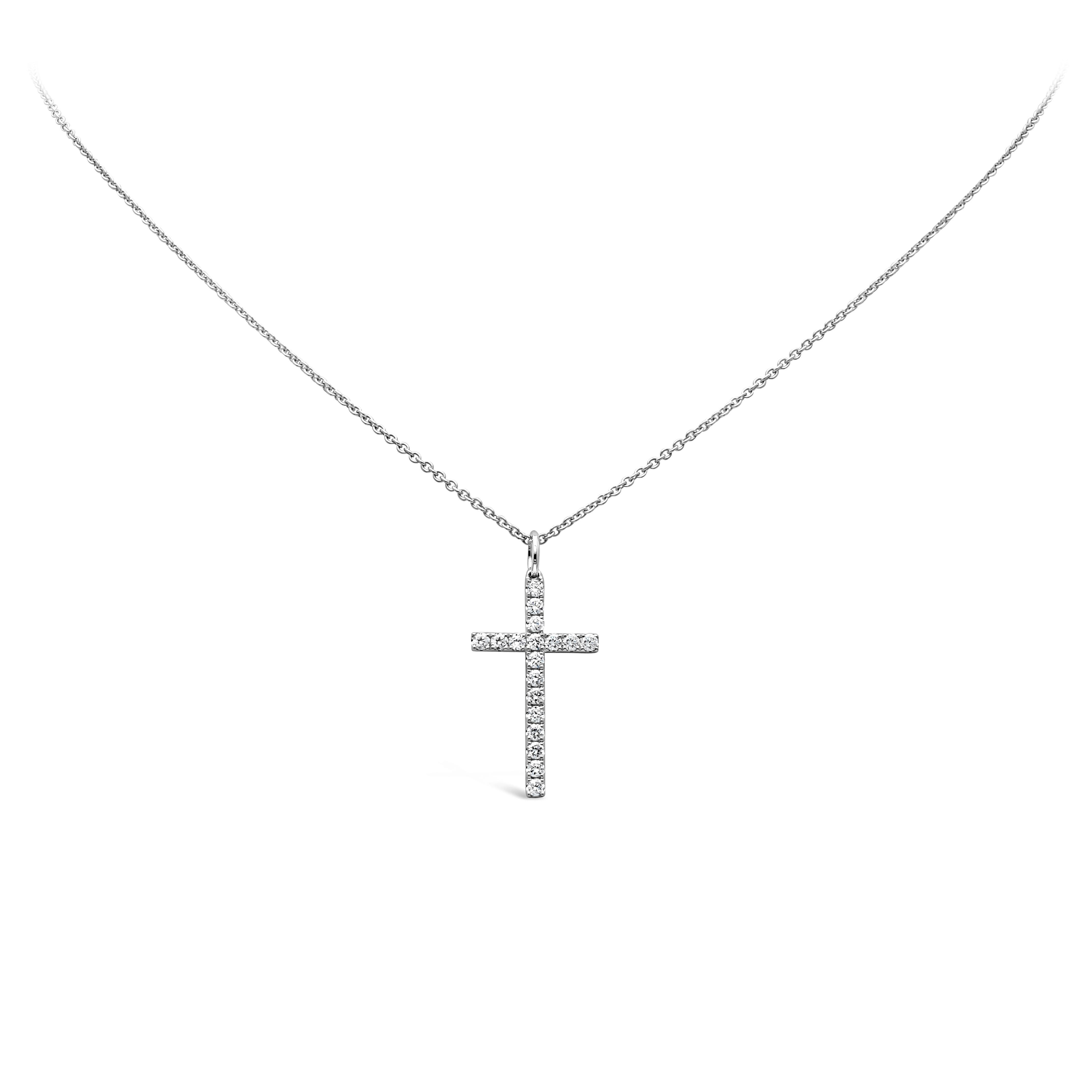 Collier pendentif simple, mettant en valeur des diamants ronds de taille brillant pesant 0.45 carat au total, de couleur G et de pureté VS, sertis sur un motif de croix religieuse. Suspendue à une chaîne en or blanc 18 carats, d'une longueur de 18