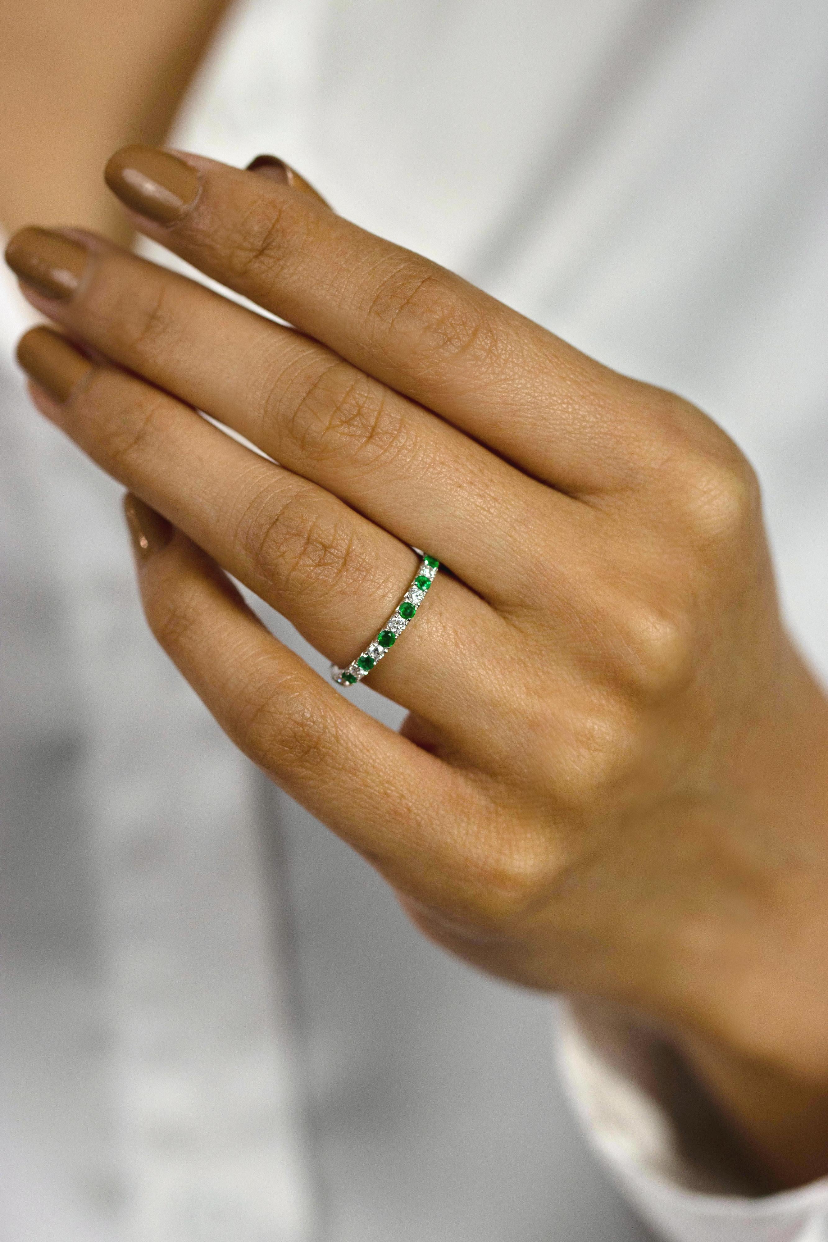 A fashionable half eternity wedding band ring showcasing color-rich green emerald elegantly alternates with white round diamonds, emerald weighs 0.24 carats and white diamonds weighs 0.26 carats. Set half-way in a french-pave setting, Made with 18K