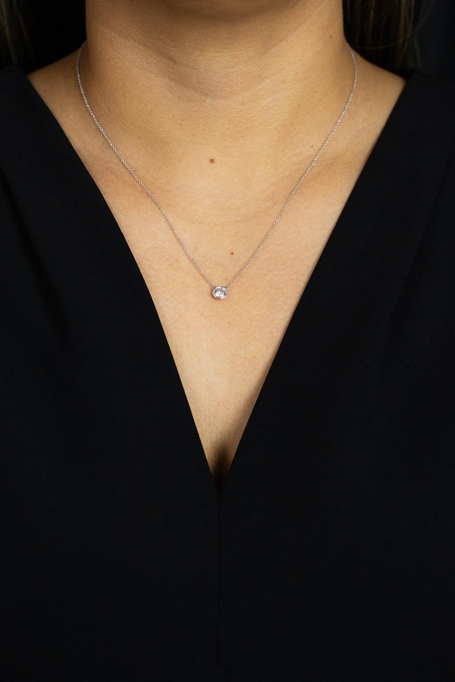 Una collana con pendente solitario semplice e versatile che mette in mostra un singolo diamante rotondo in un castone in oro bianco 14 carati. Il diamante pesa 0,51 carati. Attaccato a una catena in oro bianco da 16 pollici (regolabile su