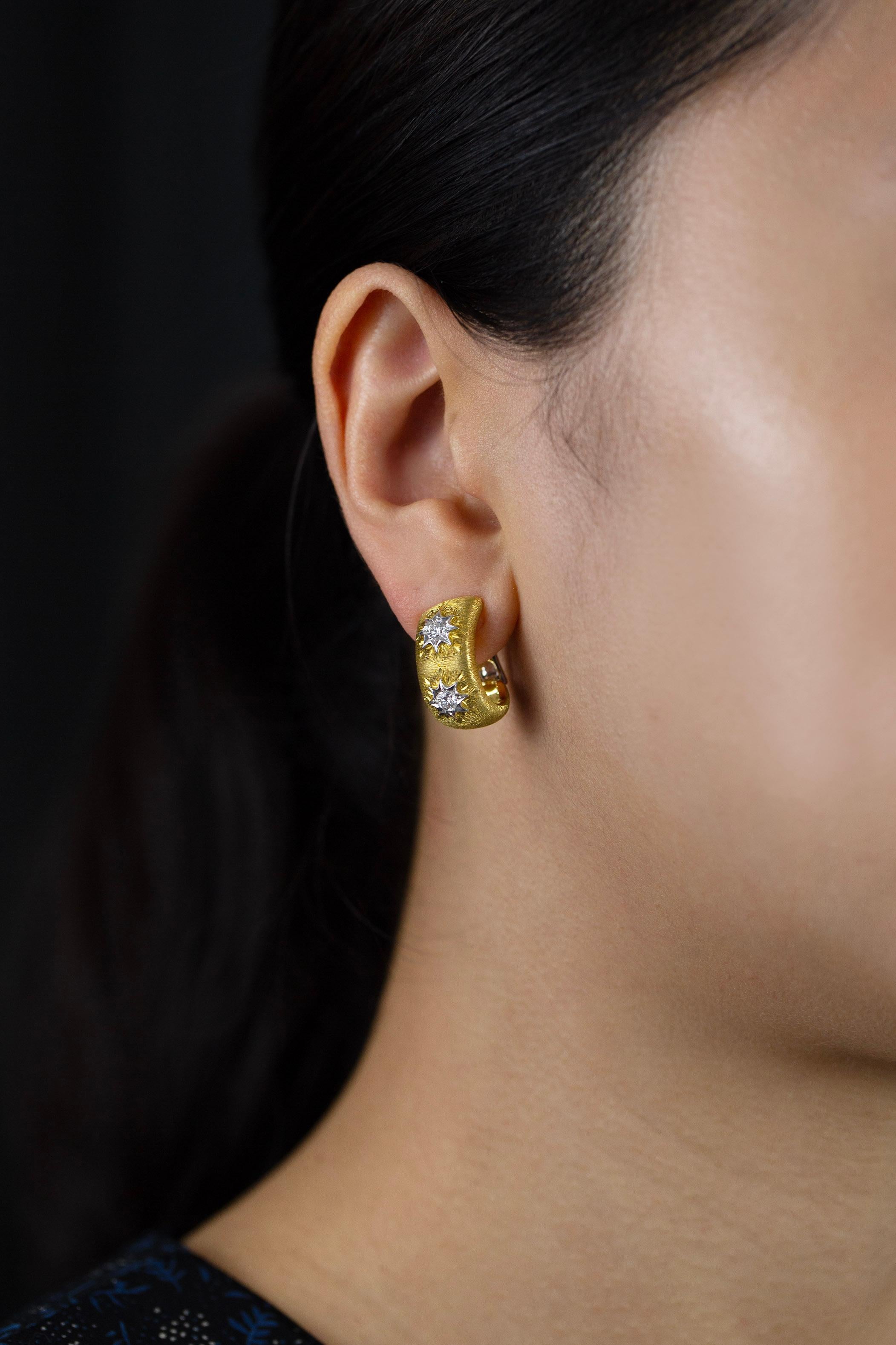 A fashionable pair of hoop earrings showcasing a brushed and domed yellow gold accented with brilliant round diamonds. Diamonds weigh 0.51 carats total, approximately F color, VS in clarity. Omega Clip with post made in 18K White Gold.

Roman