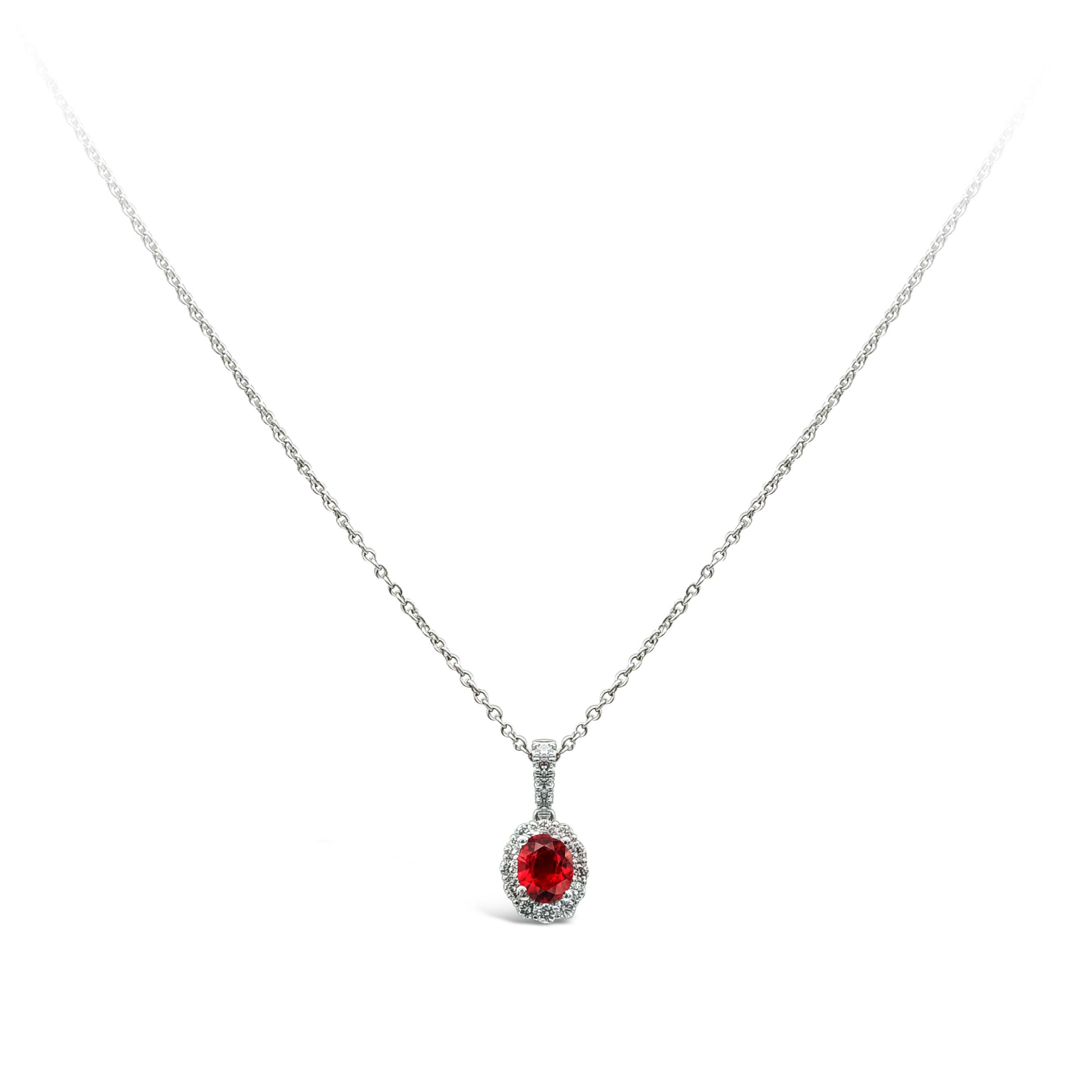 This classy and unique halo pendant necklace showcases an oval cut ruby weighing 0.41 carat, embellished by 17 pieces of round diamonds, weighing 0.18 carat total, F color and VS in clarity. Made with 14k and 18K White Gold. Suspended on 18 inches