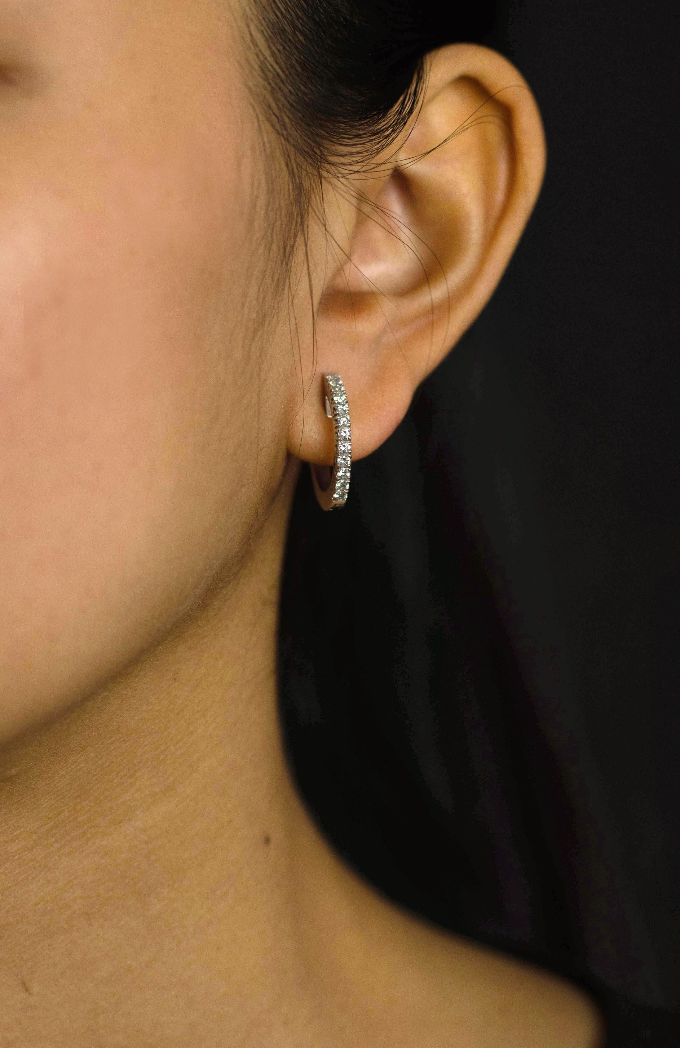 A simple pair of hoop earrings showcasing a row of round brilliant diamonds weighing 0.64 carats total, set in a shared prong basket setting. Finely made in 18k white gold.

Style available in different price ranges. Prices are based on your