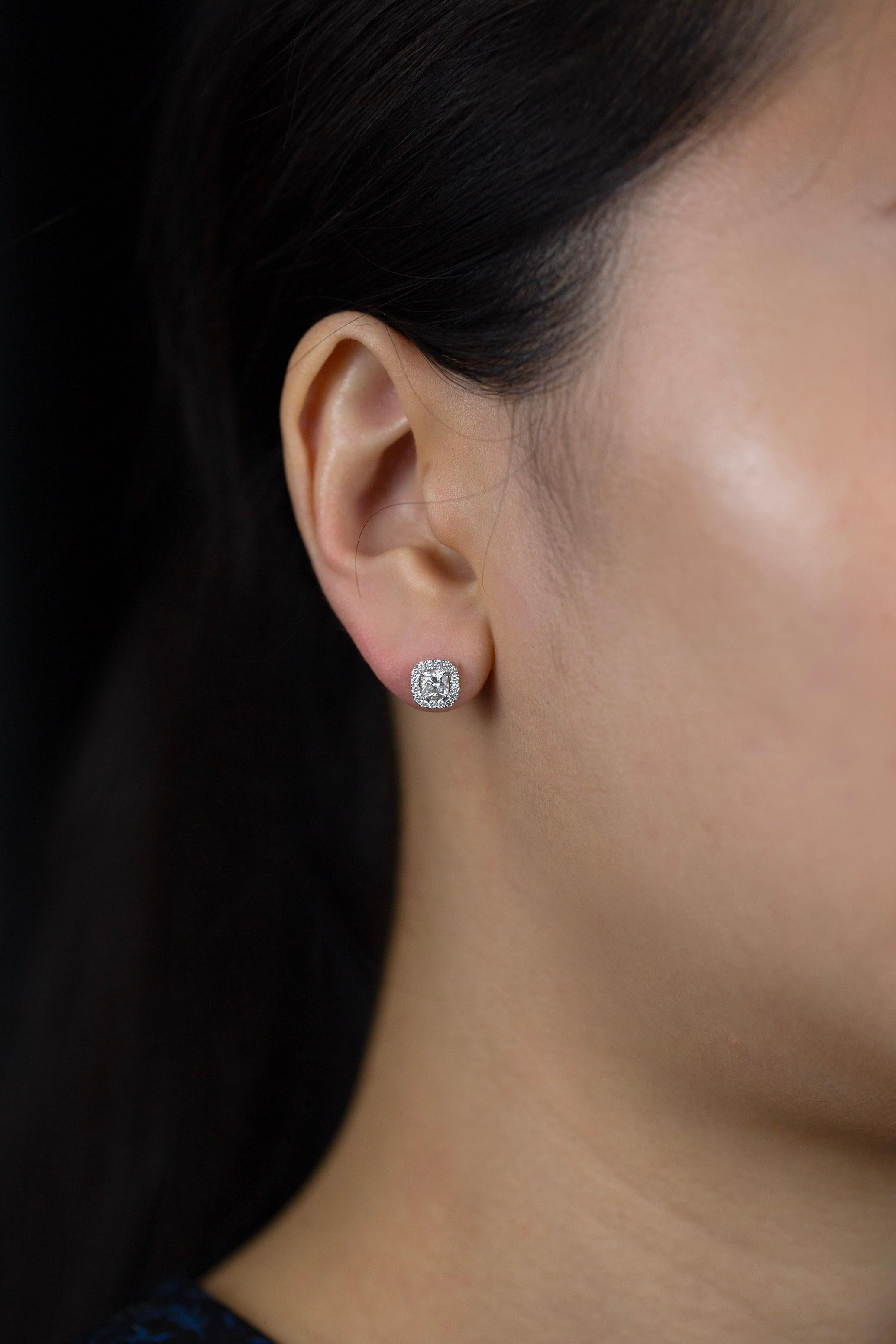 Ces boucles d'oreilles simples mais élégantes mettent en valeur 2 diamants taille coussin pesant 0,65 carat au total, de couleur F et de pureté VS. Entouré d'une seule rangée de 32 diamants ronds brillants pesant 0,17 carat au total. Fabriqué en