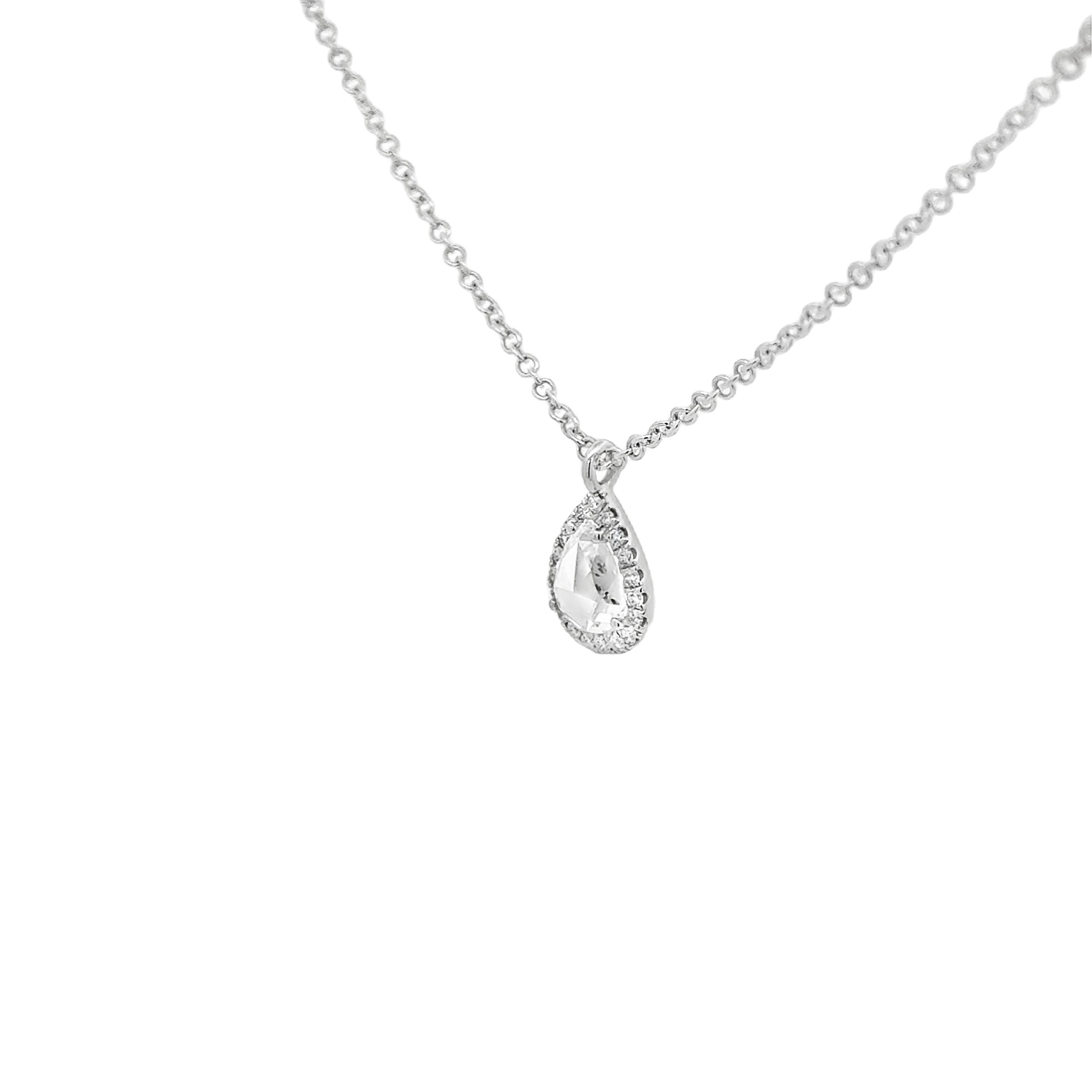 Superbe collier à pendentif, composé d'une poire de 0,67 carat et d'un diamant taillé en rose, montés sur quatre griffes arrondies. Accentuée par un halo de diamants ronds de taille brillant pesant 0,12 carat au total, sertis sur une monture