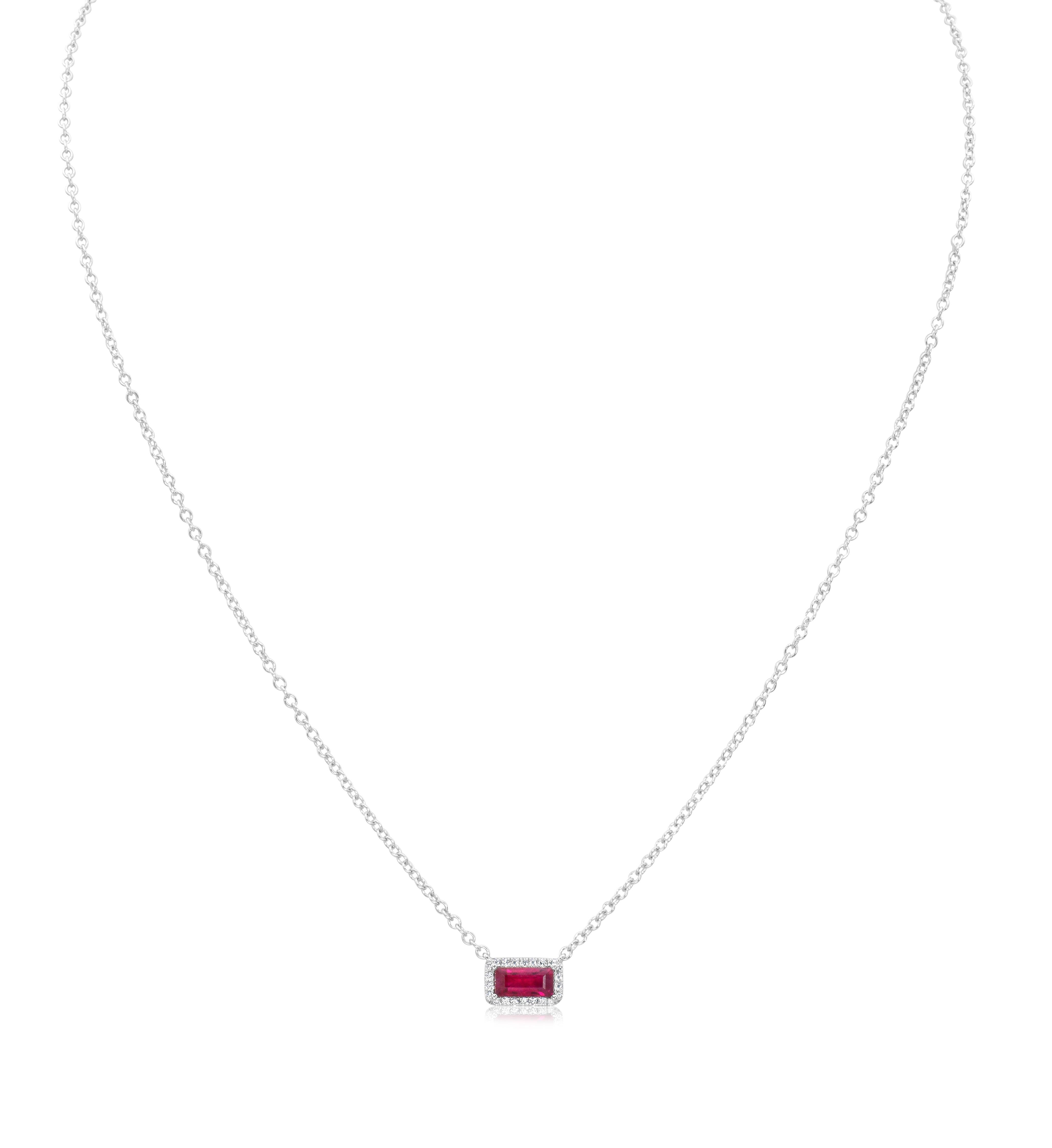A lovely pendant necklace, showcasing a 0.67 carat rectangular ruby, set on a classic four prong setting. Accented by a halo of round cut diamonds weighing 0.13 carat total, set with a pavé design. Finely made with 18K white gold. Attached to a