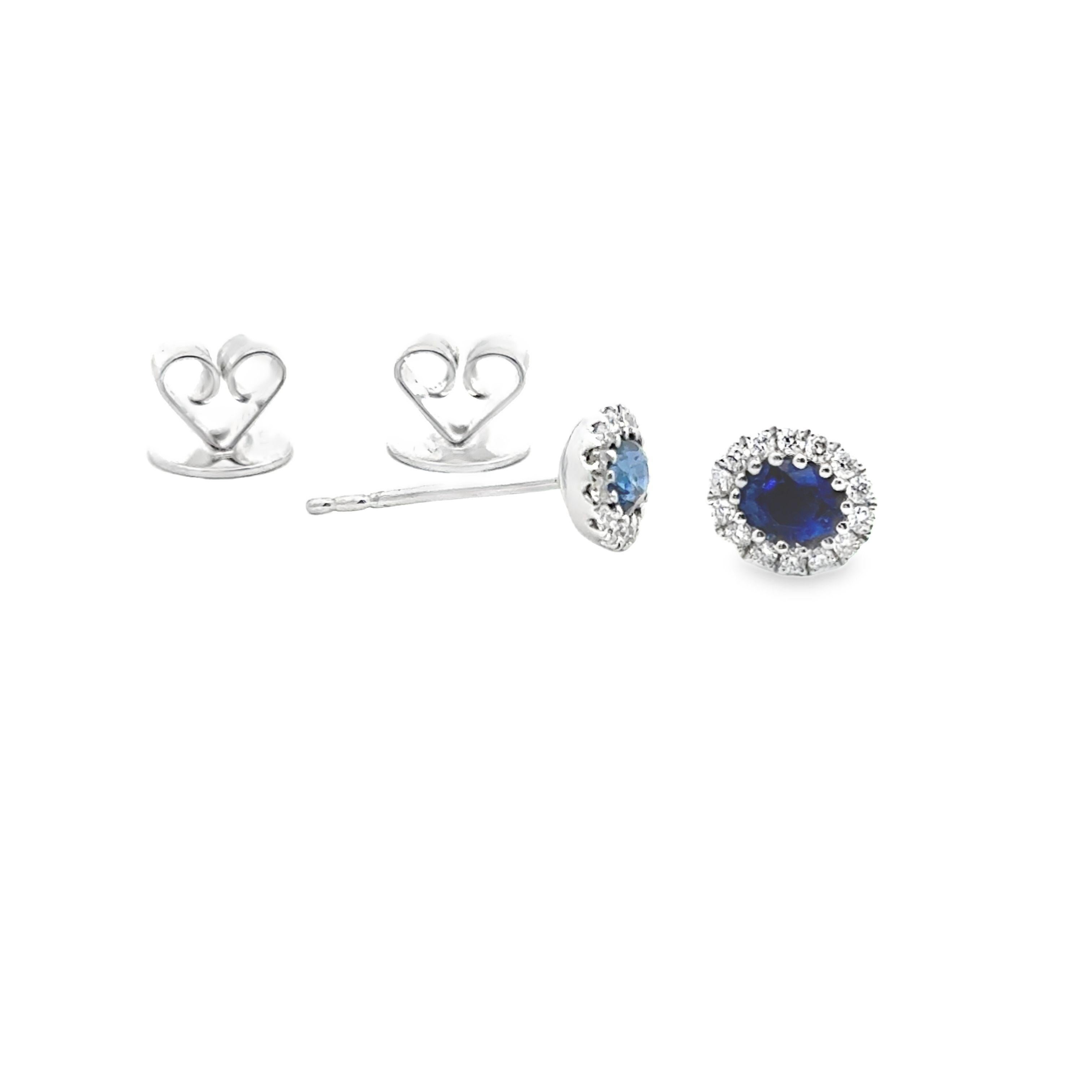 A chic pair of stud earrings, featuring oval cut sapphires weighing 0.68 carat total, set on a multi-prong setting. Accented by a halo of round cut diamonds weighing 0.17 carat total, set in a beautiful pavé design. Finely made with 18K white gold.