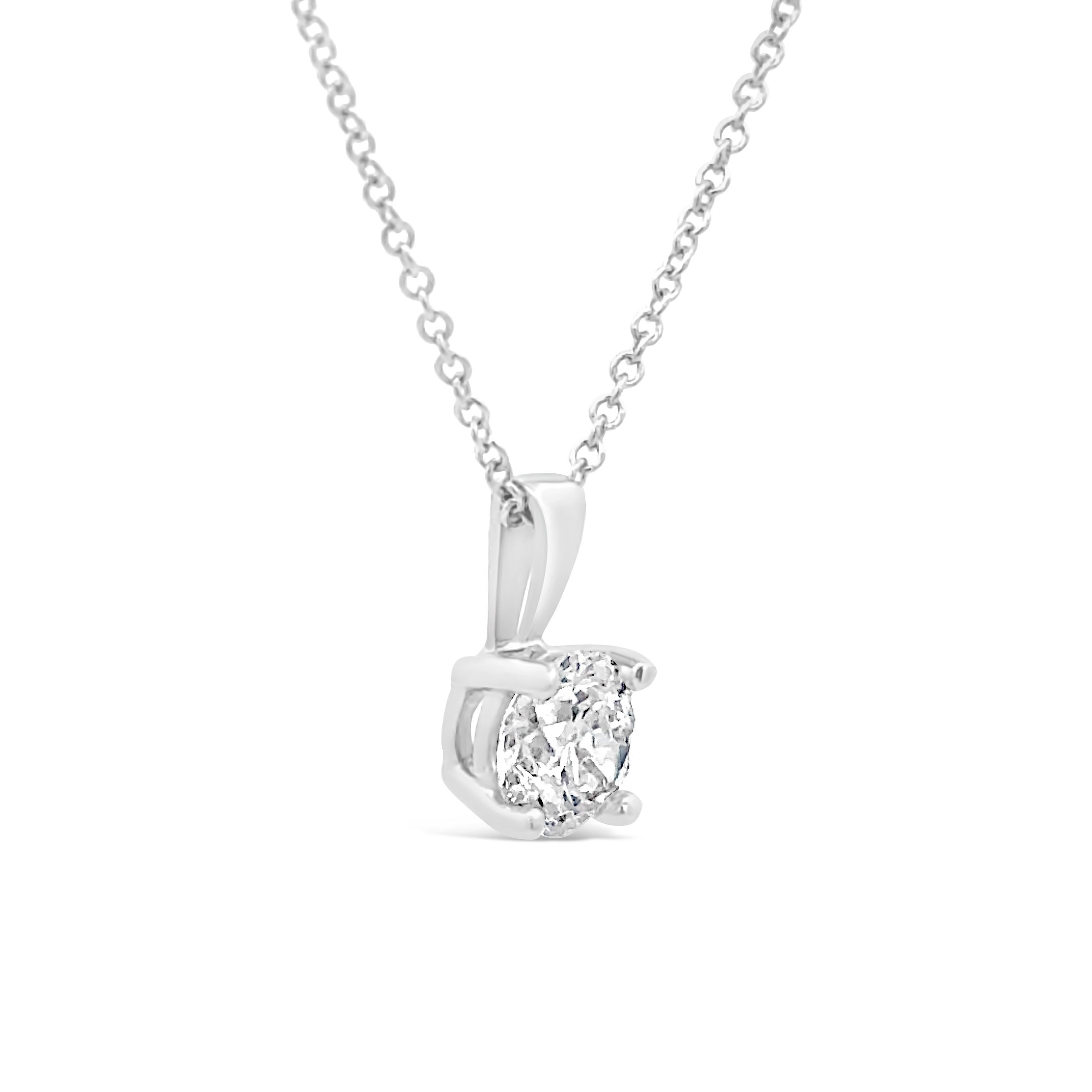 Collier pendentif solitaire simple, mettant en vedette un diamant rond de taille brillant de 0,70 carat de couleur E et de pureté SI2, serti sur une monture à quatre griffes. Finement réalisé en or blanc 18 carats. Suspendue à une chaîne en or