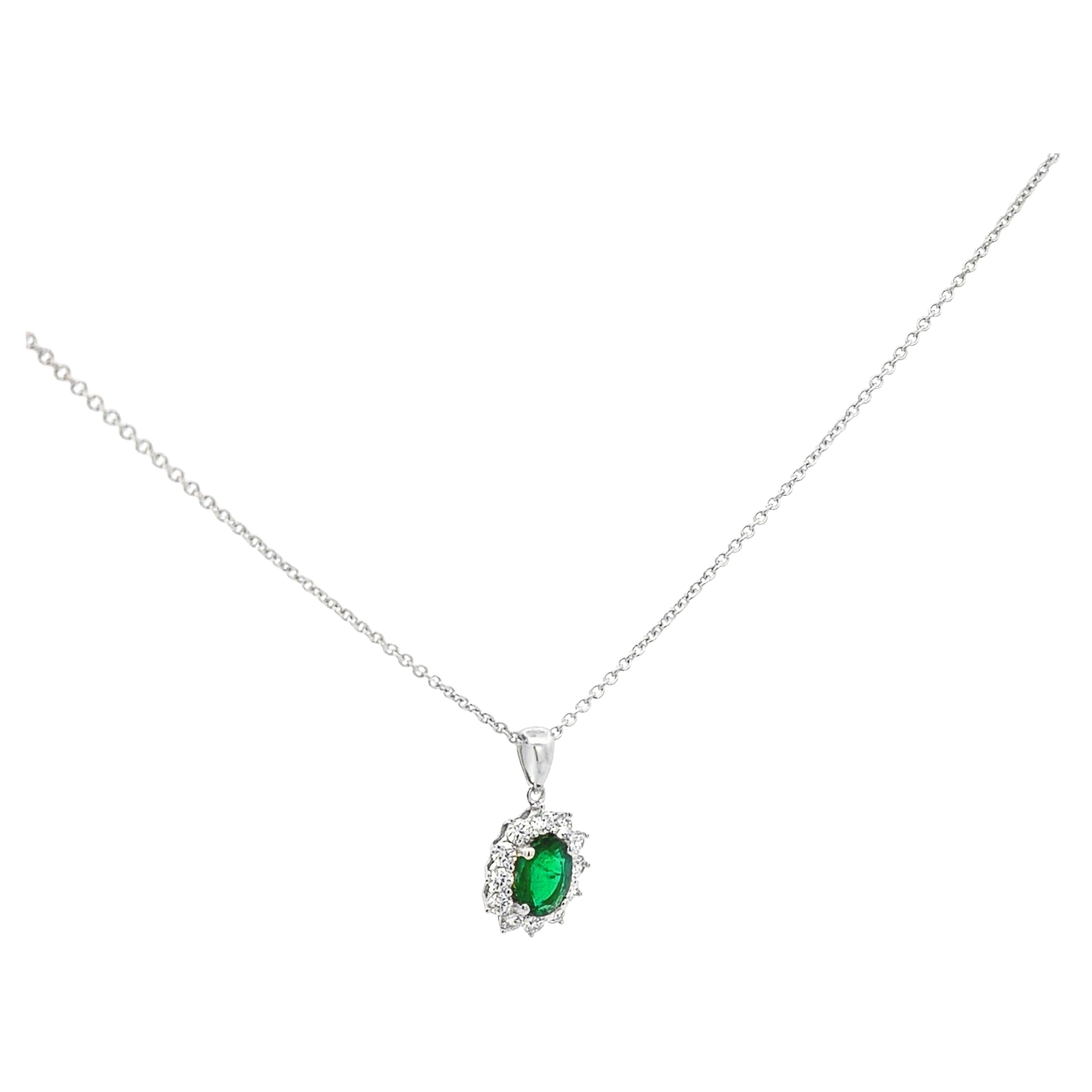 Precioso collar colgante, con una esmeralda de 0,74 quilates de talla oval, engastada en cuatro puntas redondeadas. Acentuado por un halo de diamantes redondos de talla brillante con un peso total de 0.46 quilates, engastados con un motivo floral.