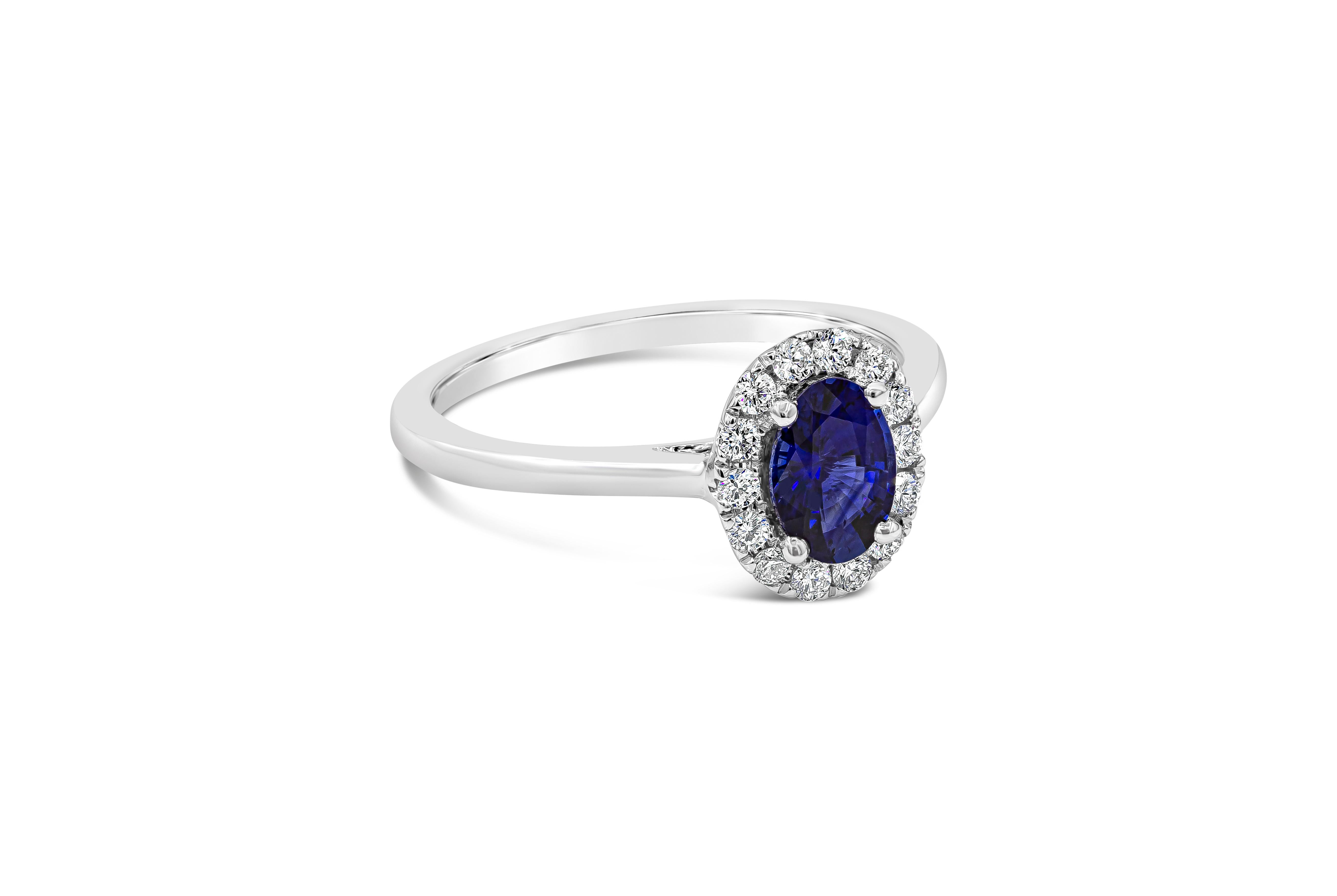 A classic halo engagement ring featuring a color-rich blue sapphire weighing 0.76 carats total, surrounded by a single row of round brilliant diamonds weighing 0.19 carats total. Set in a thin polished 18k white gold mounting. Size 6.25

Style