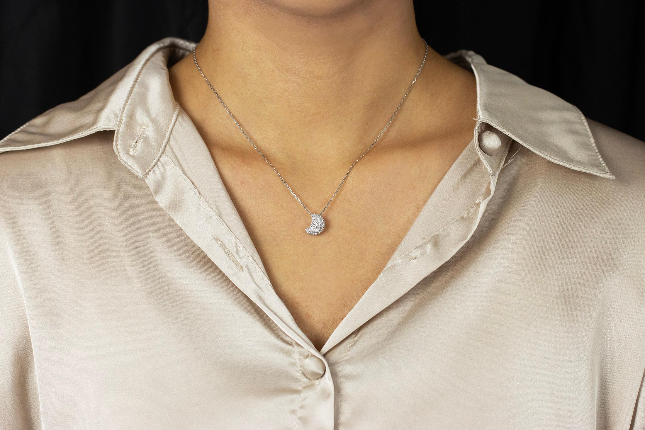 This simple yet brilliant pendant necklace showcasing a three dimensional crescent moon, micro-pave set with round brilliant diamonds. Diamonds weigh 0.77 carats total. Made in 18K white gold. Suspended on an 16 inch white gold chain.

Roman Malakov
