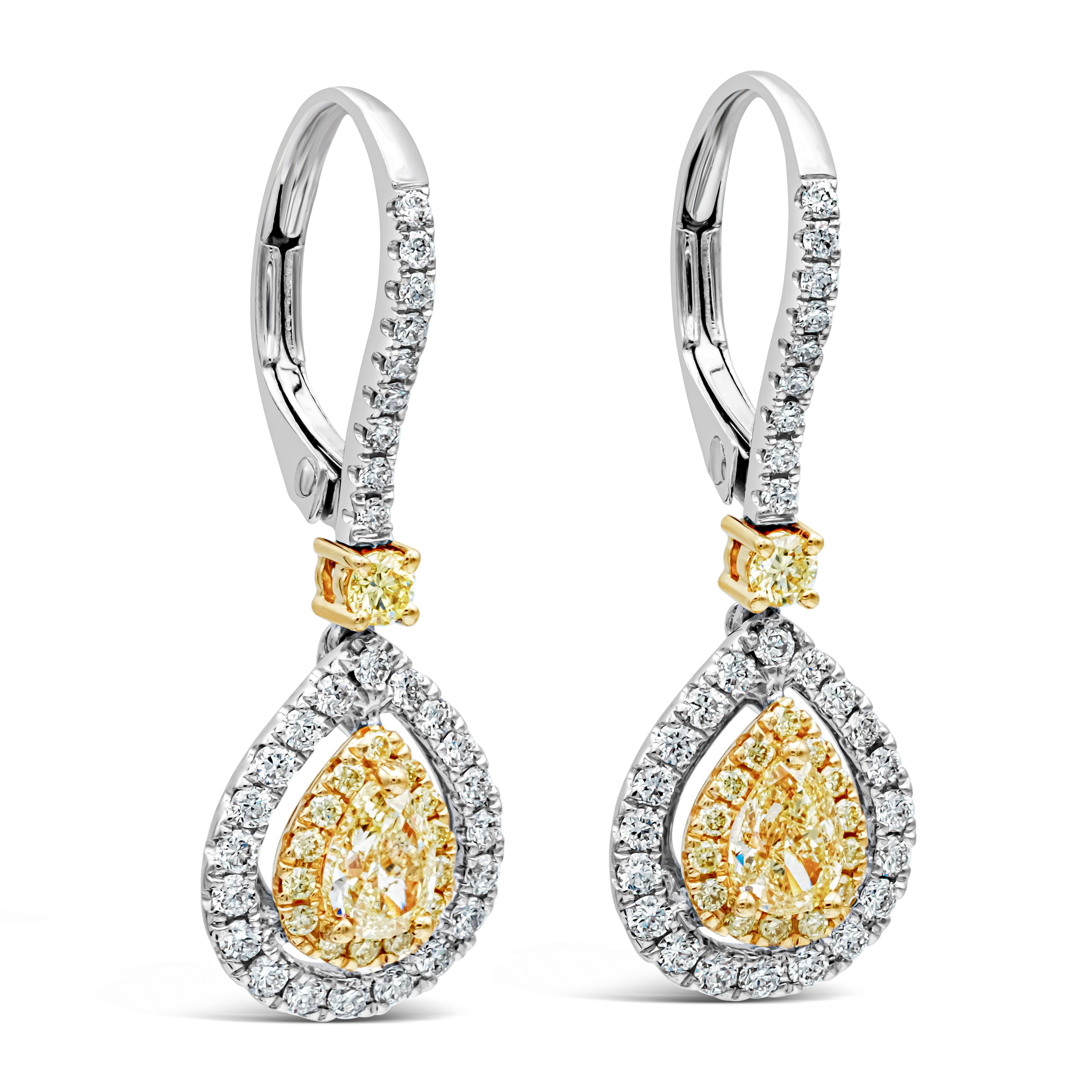 This beautiful pair of earrings features a pear shape yellow diamond surrounded by a round yellow diamond halo with an outer halo of round white diamonds. Hanging from a diamond encrusted lever-back with a single round yellow diamond in between.