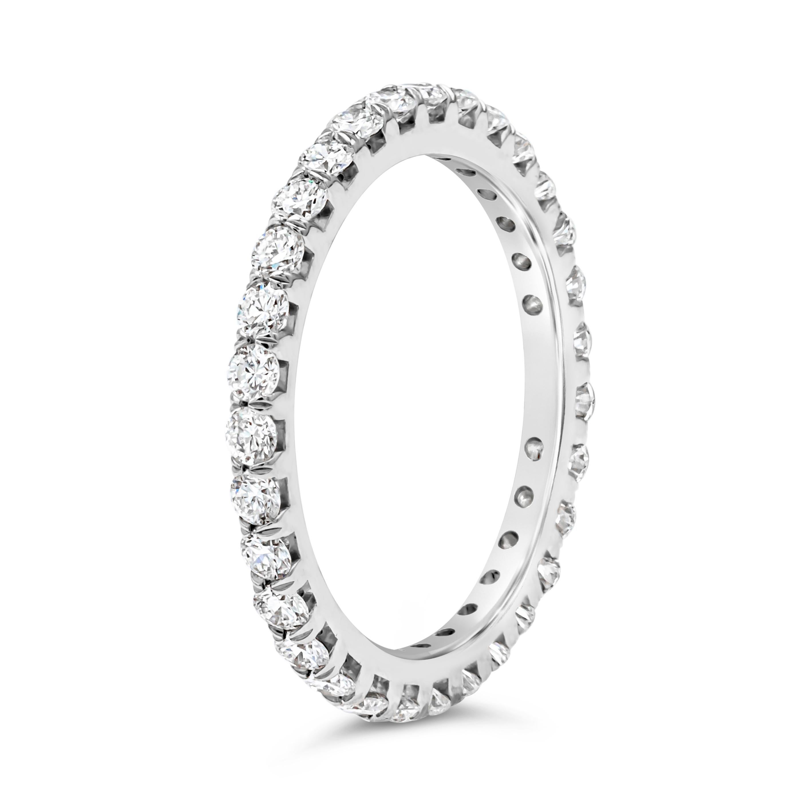 A classy and simple eternity wedding band showcasing a line of 31 brilliant round cut diamonds weighing 0.99 carats total, G color and VS in clarity, set in a four prong basket setting and French pave set. Finely made in platinum. Size 6.5 US
