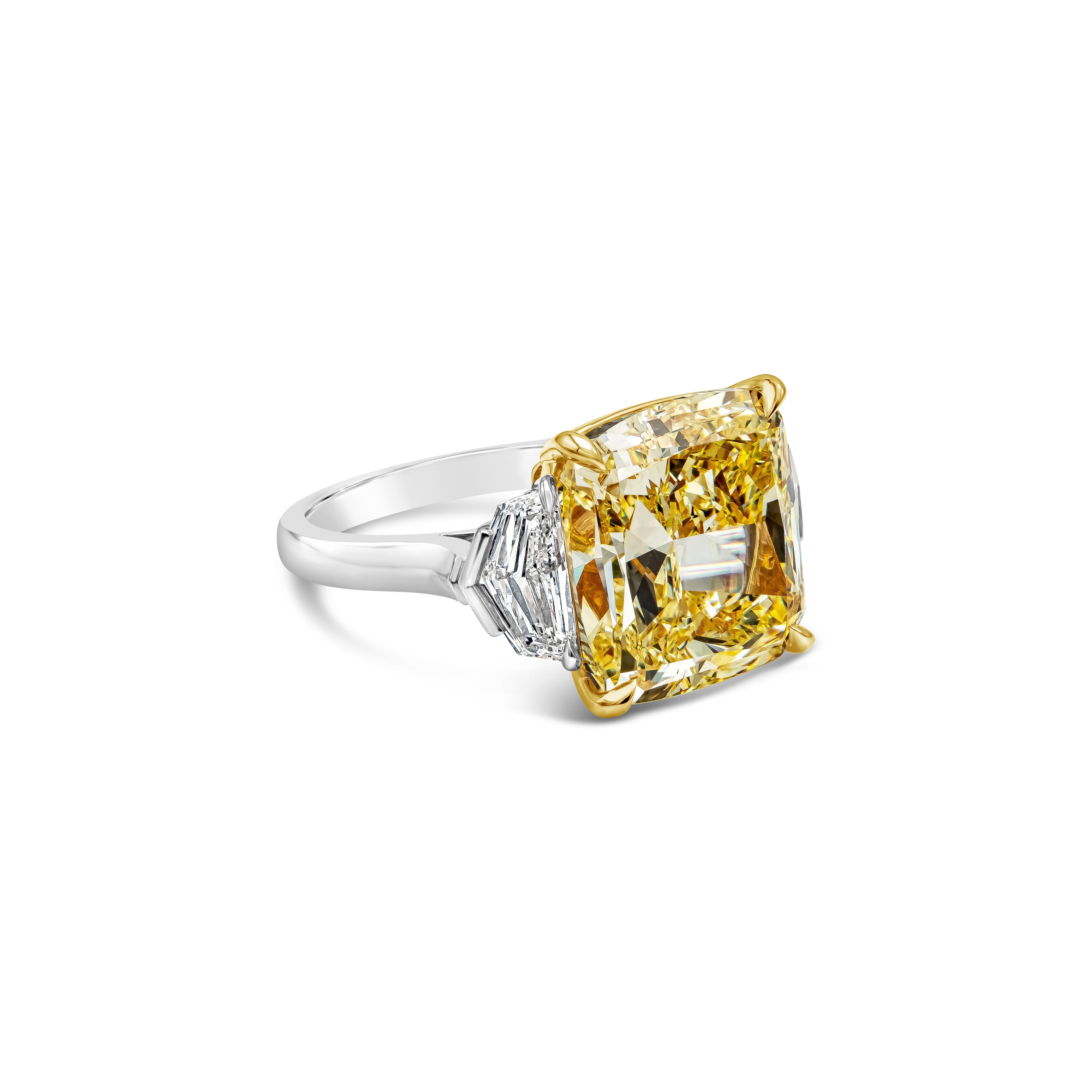 Elegantly crafted three stone engagement ring features a 10.02 carat cushion cut diamond certified by GIA as fancy yellow color, VS2 in clarity. Flanking the center stone are 2 GIA certified epaulette diamonds, D color and VS in clarity, set in