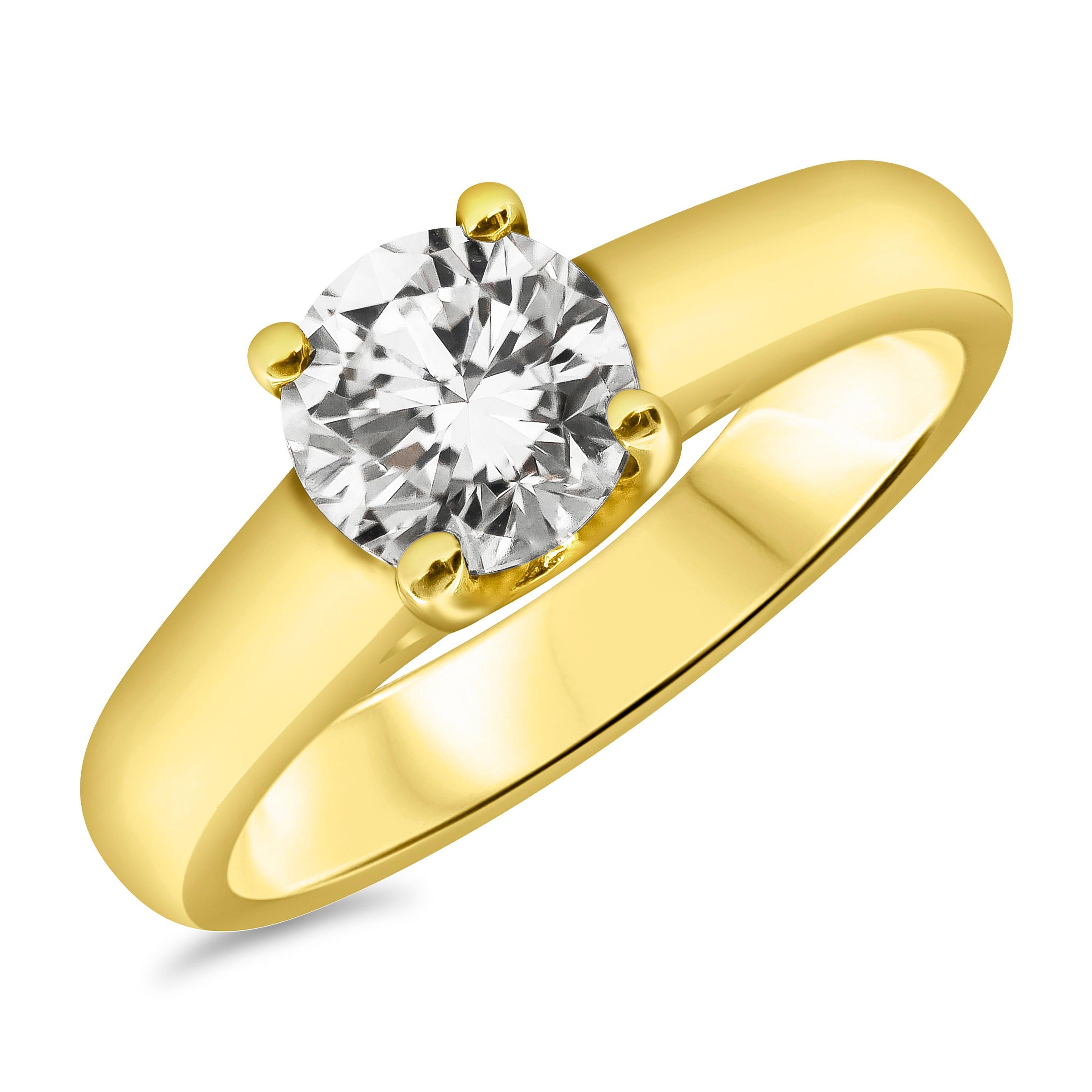 Une magnifique bague de fiançailles solitaire mettant en valeur un diamant rond brillant de 1,02 carats brille élégamment sous les feux de la rampe dans une composition arrondie en or jaune 18 carats. Des griffes entrelacées maintiennent le diamant