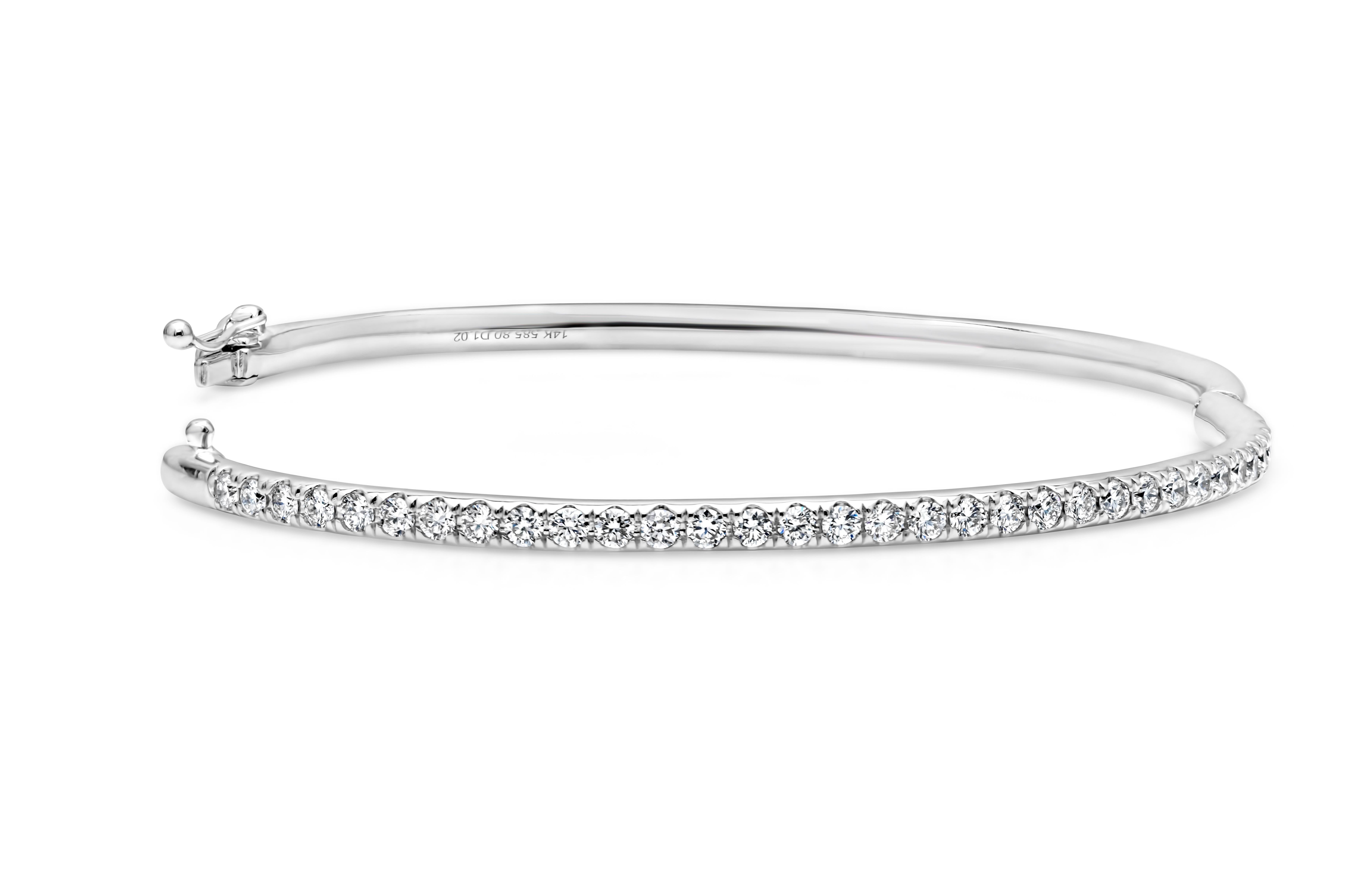 Showcasing a simple but elegant small wrist bangle bracelet set with 32 brilliant round cut diamonds weighing 1.02 carats total, F color and VS in clarity. Has a clasp to slip and wear the bangle securely. Finely made in 14k white gold and 6.50