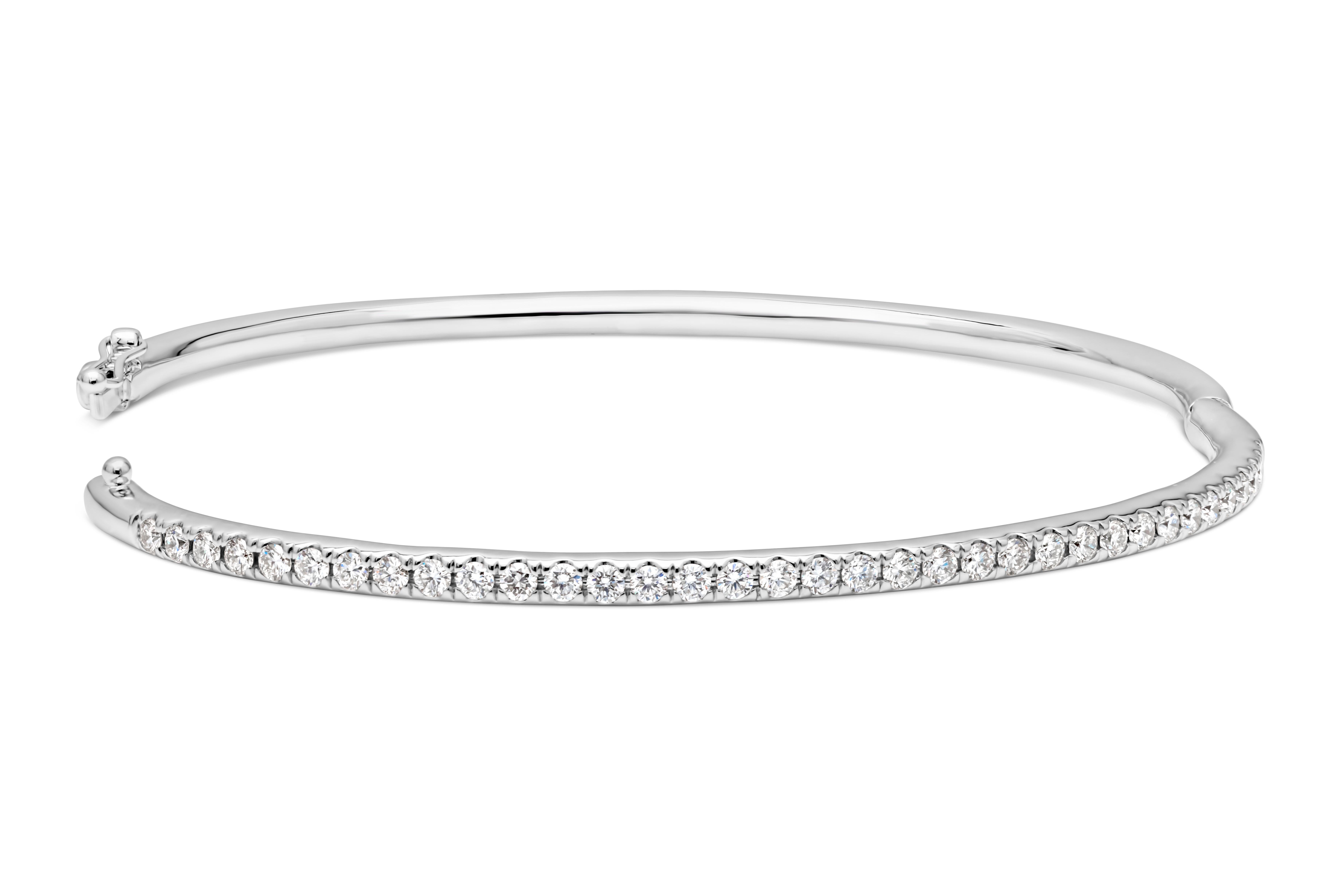 Una elegante pulsera brazalete grande, con 35 diamantes redondos de talla brillante que pesan 1,10 quilates en total con color F y claridad VS. Finamente engastada en oro blanco de 14 quilates con un cierre para llevarla con seguridad, mide 7,57