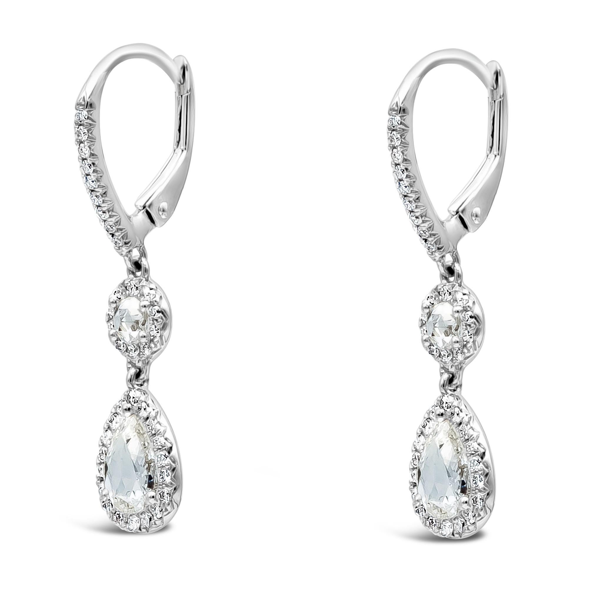 Cette magnifique paire de boucles d'oreilles pendantes est ornée d'un diamant poire et d'un diamant rond pesant au total 1,10 carats. Le tout est serti dans un halo. Il est suspendu à un levier incrusté de diamants. Fabriqué en or blanc 18K.

Roman