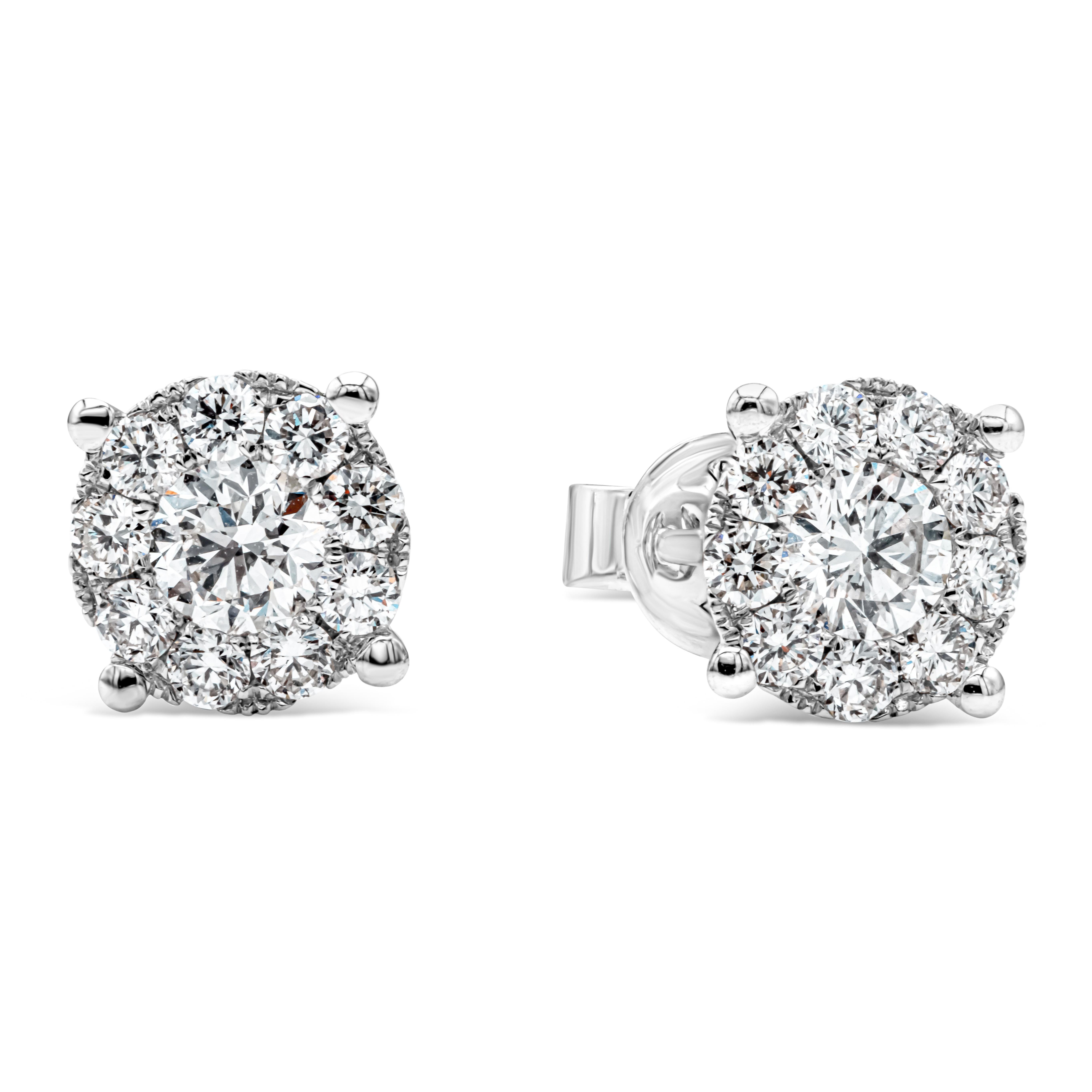 A brilliant pair of stud earrings showcasing a cluster of round brilliant diamonds weighing 1.13 carats total, F-G color and VS-SI in clarity, set in a classic four prong basket setting. The earrings exude the look of a one carat each diamond stud