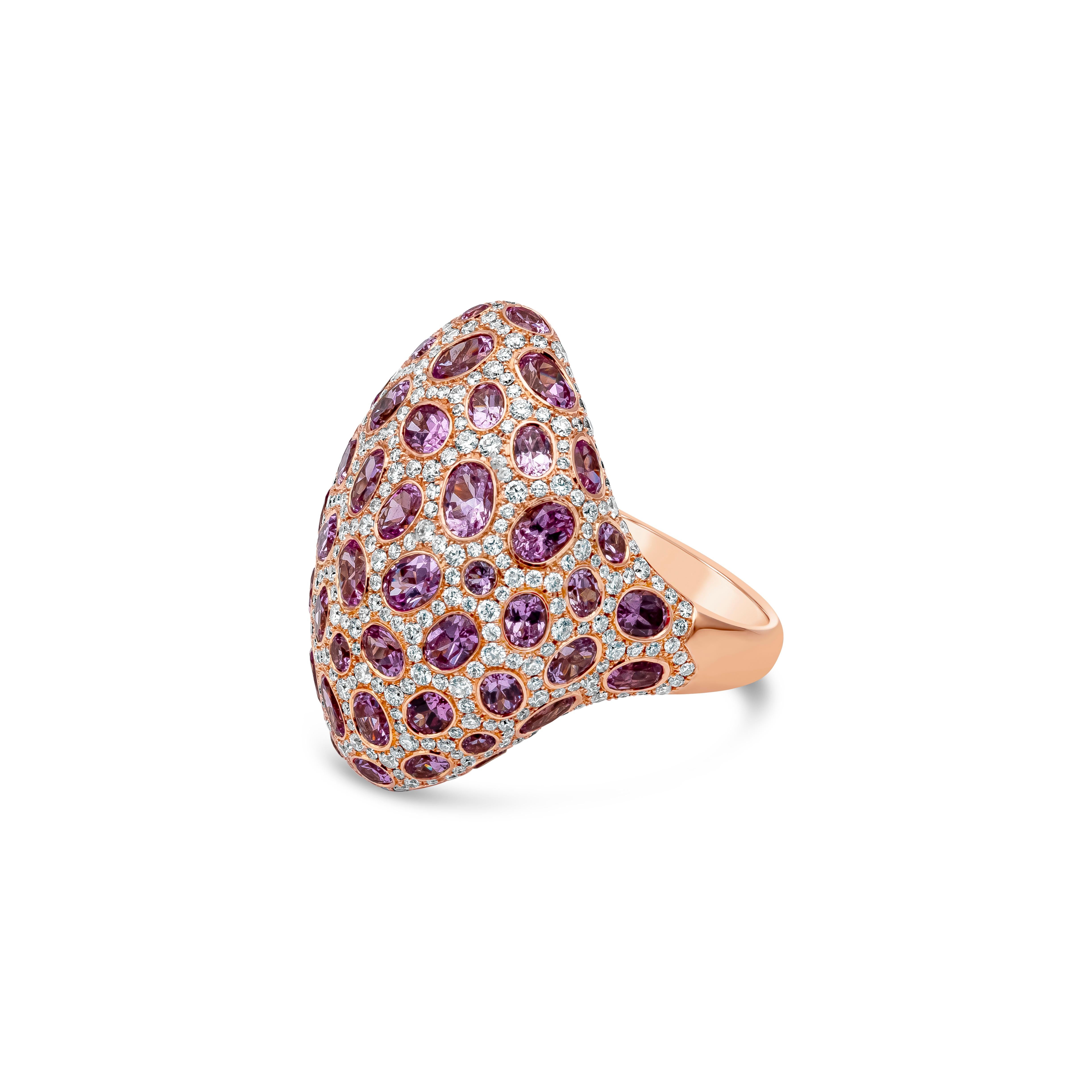 An enchanting piece of fashion ring showcasing 64 oval cut pink sapphires weighing 9.91 carats, bezel set in a cluttered design, surrounded by brilliant round melee diamonds around weighing 2.18 carats total. Made in a dome shape in 18K Rose Gold,