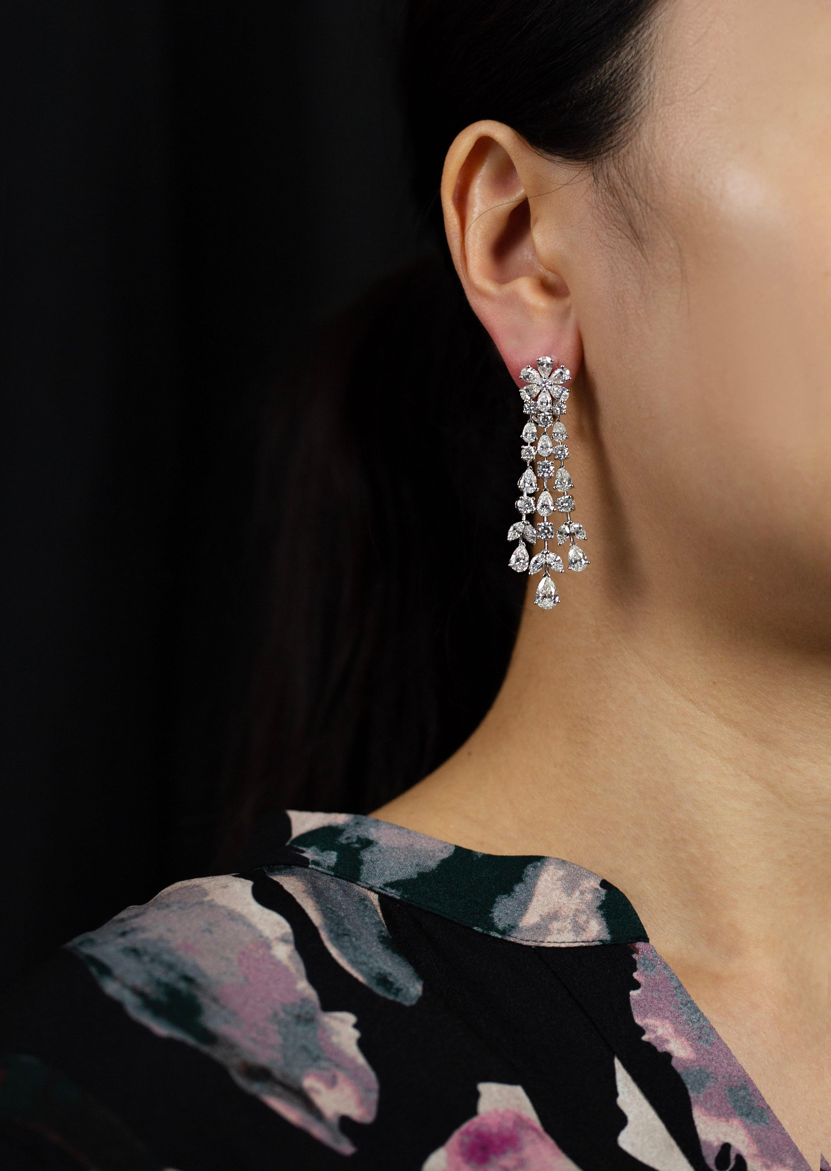 A fashionable and spectacular chandelier earrings showcasing three rows of mixed cut diamonds, set in a elegant waterfall floral-motif design weighing 12.45 carats total. Omega Clip with post and Finely Made in 18k white gold. 

Style available in