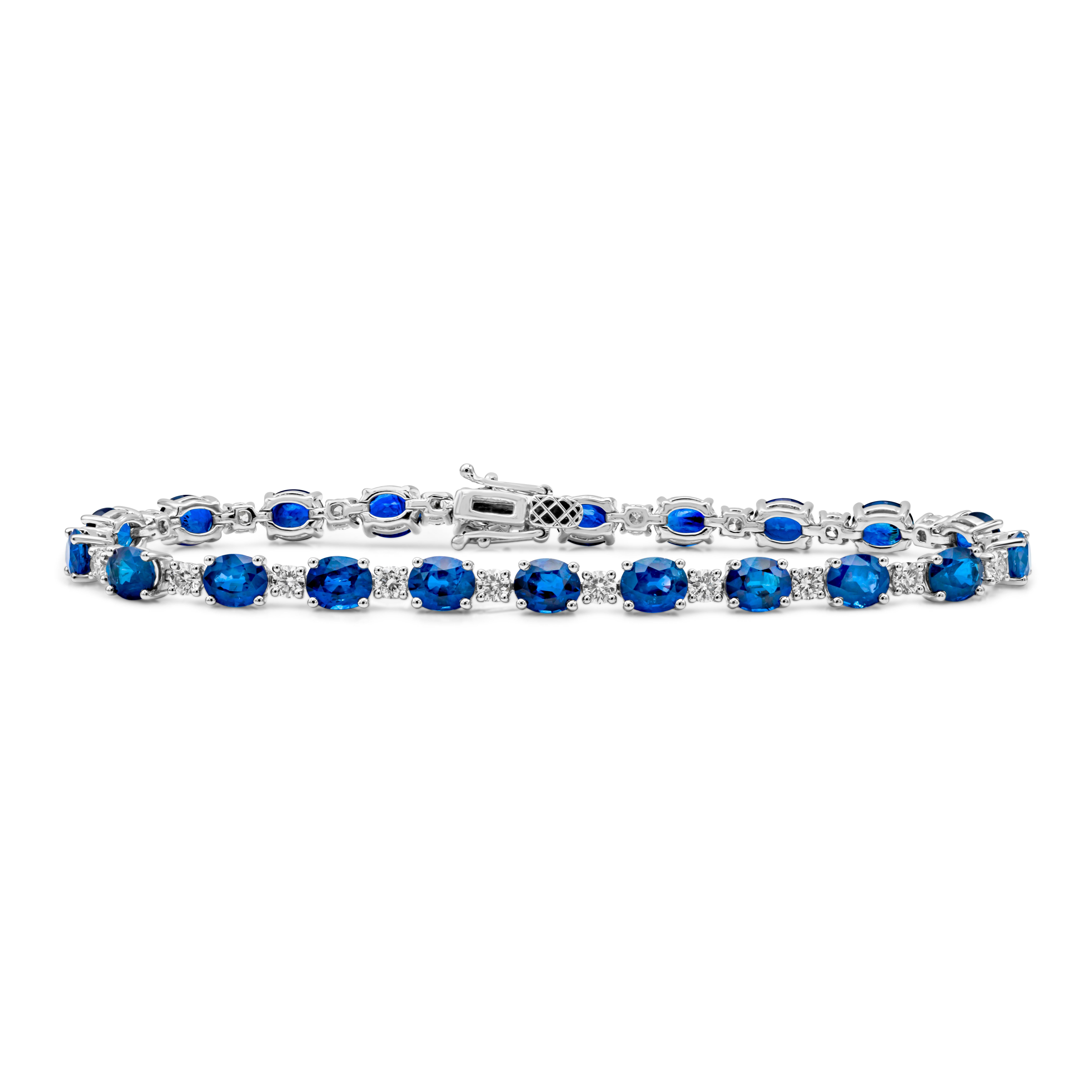 This beautiful tennis bracelet showcases a color-rich oval cut blue sapphires weighing 12.56 carats total, set in a classic four prong setting. Evenly spaced by brilliant round cut diamonds weighing 1.67 carats total, G color and VS2 in clarity, set