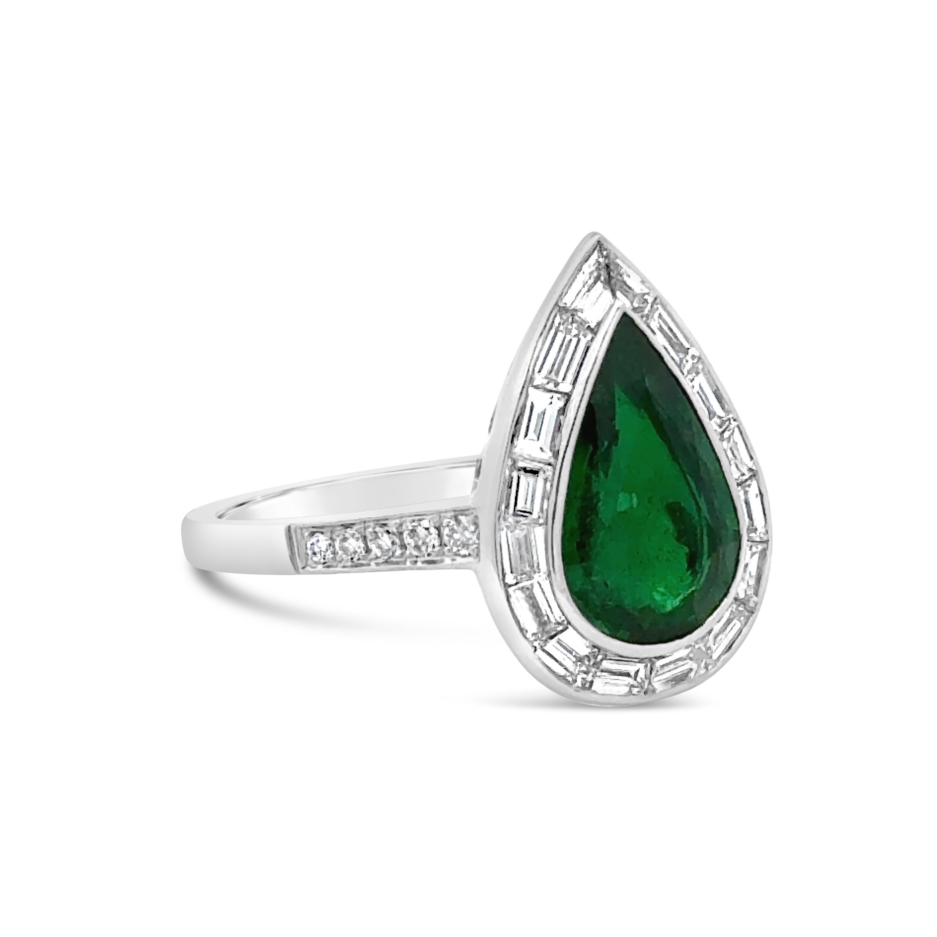 A gorgeous engagement ring, featuring a 1.26 carats pear shape Zambian emerald, bezel-set in platinum. Surrounded by tapered baguette diamonds and accented with round cut diamonds on the shank in a half-way setting. Accent diamonds weigh 0.67 carat