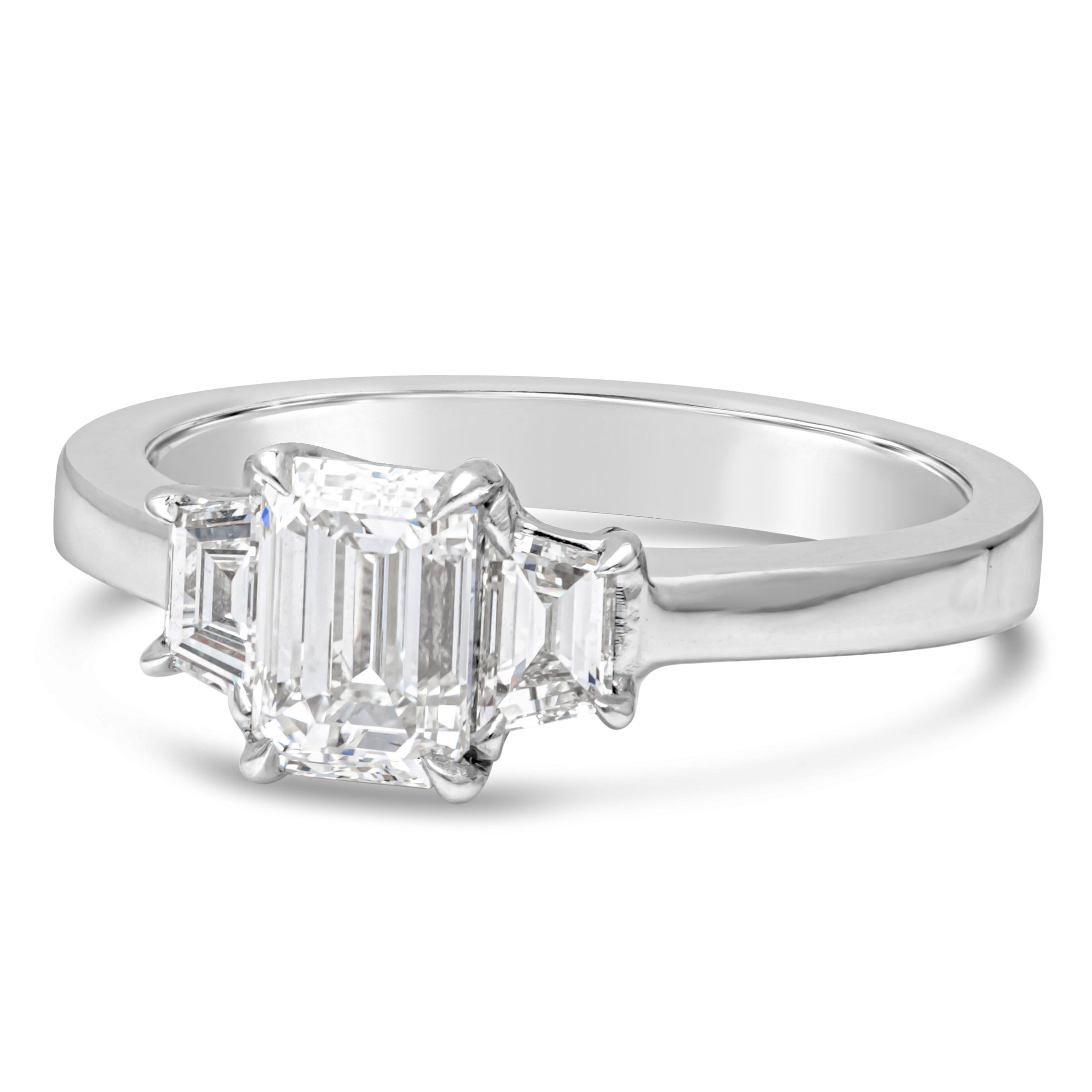 Elegantly made three stone engagement ring features a 0.93 carats emerald cut diamond set in platinum four prong setting. Flanked by trapezoid-cut diamonds on each side, weighing 0.33 carats total set in polished platinum mounting. Size 6.25 US,