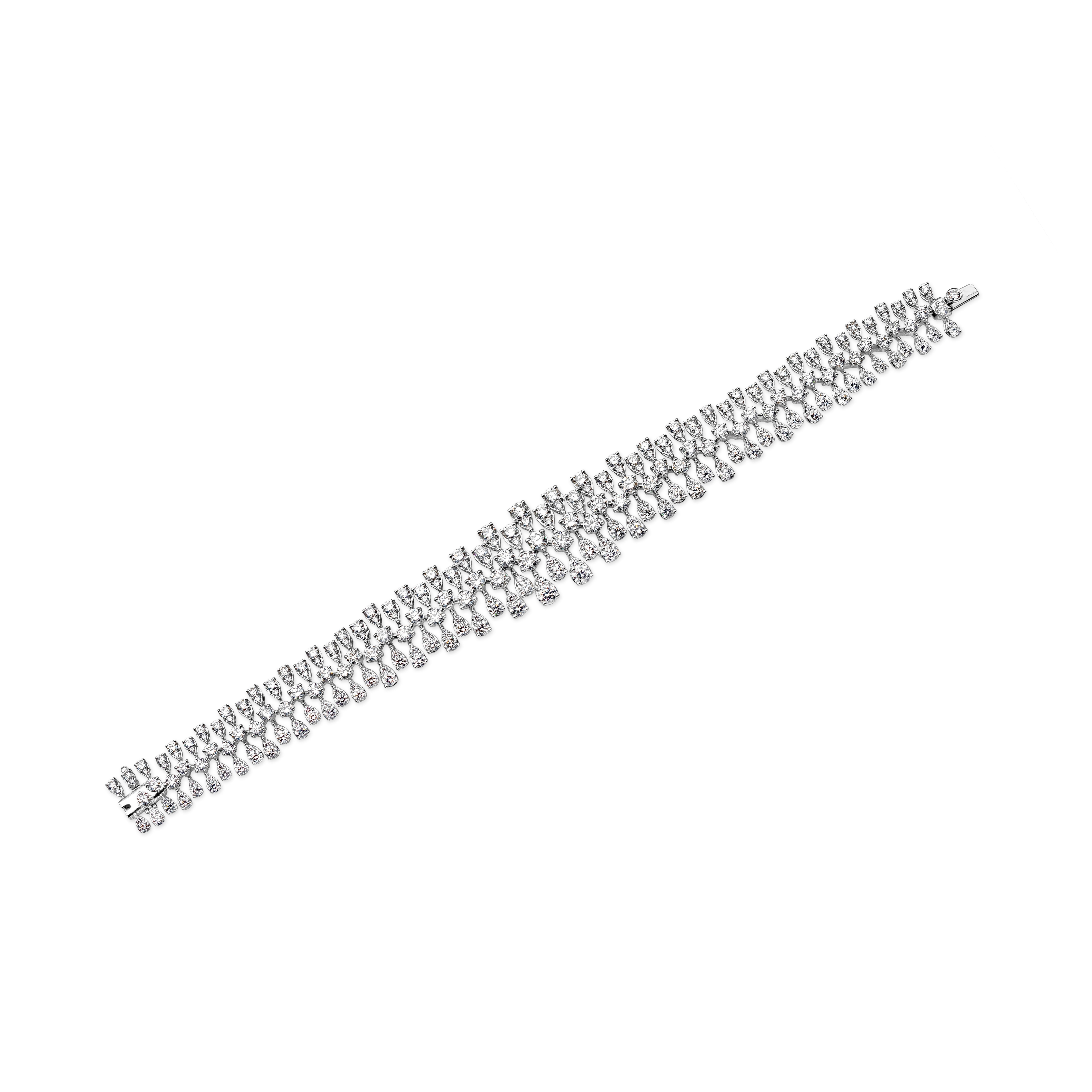 This elegant and sophisticated diamond bracelet showcase a row of pear shape and round brilliant diamonds that weighs 29.50 grams. Diamonds weigh 12.94 carats total and has a measurement of 177mm in length and 12mm-20mm in width. Made in 18k white