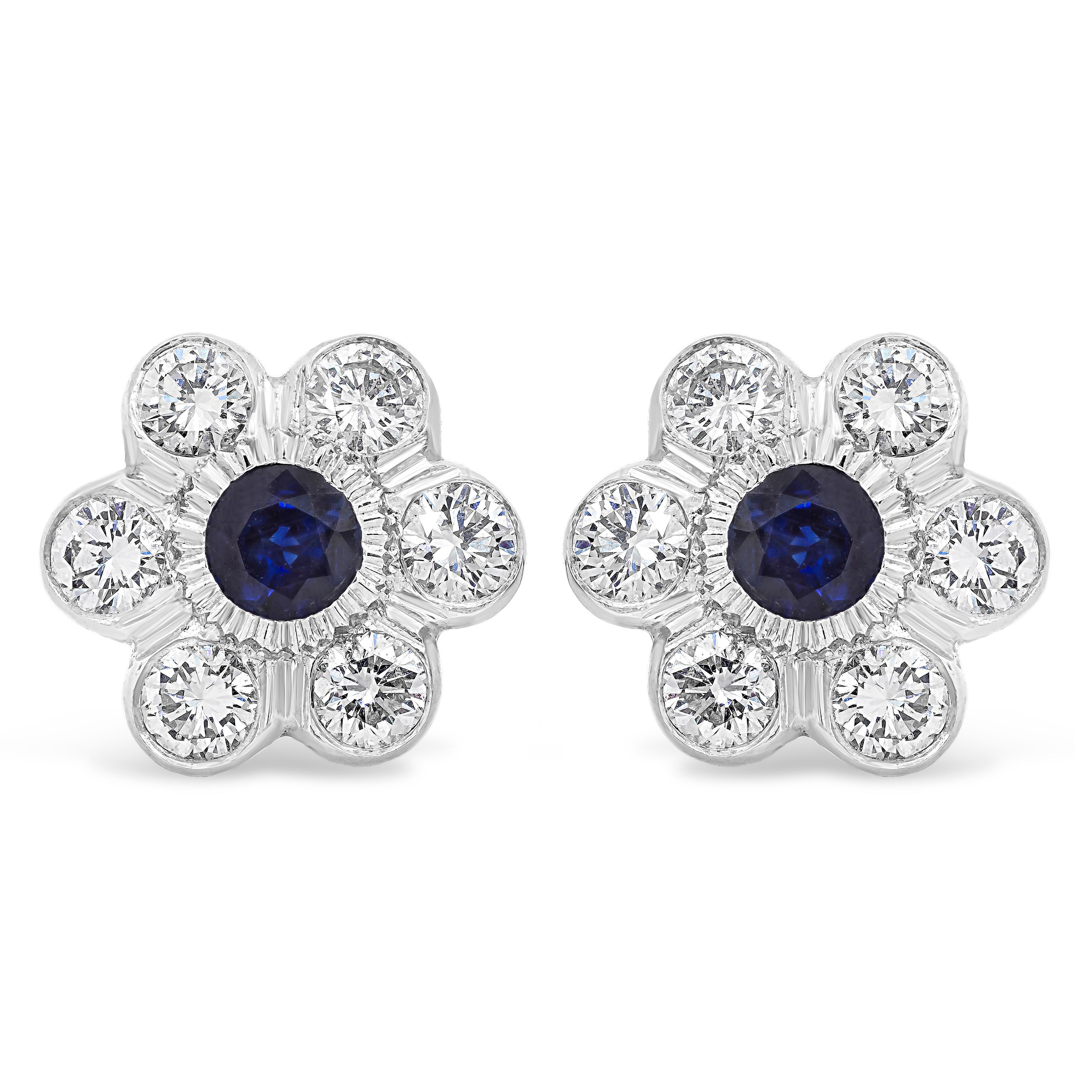 A chic and unique stud earrings showcasing 2 brilliant round blue sapphires weighing 1.33 carats total in the center, set in a beautiful flower-motif design. Surrounded by a row of round brilliant diamonds weighing 2.47 carats total. Finely made in