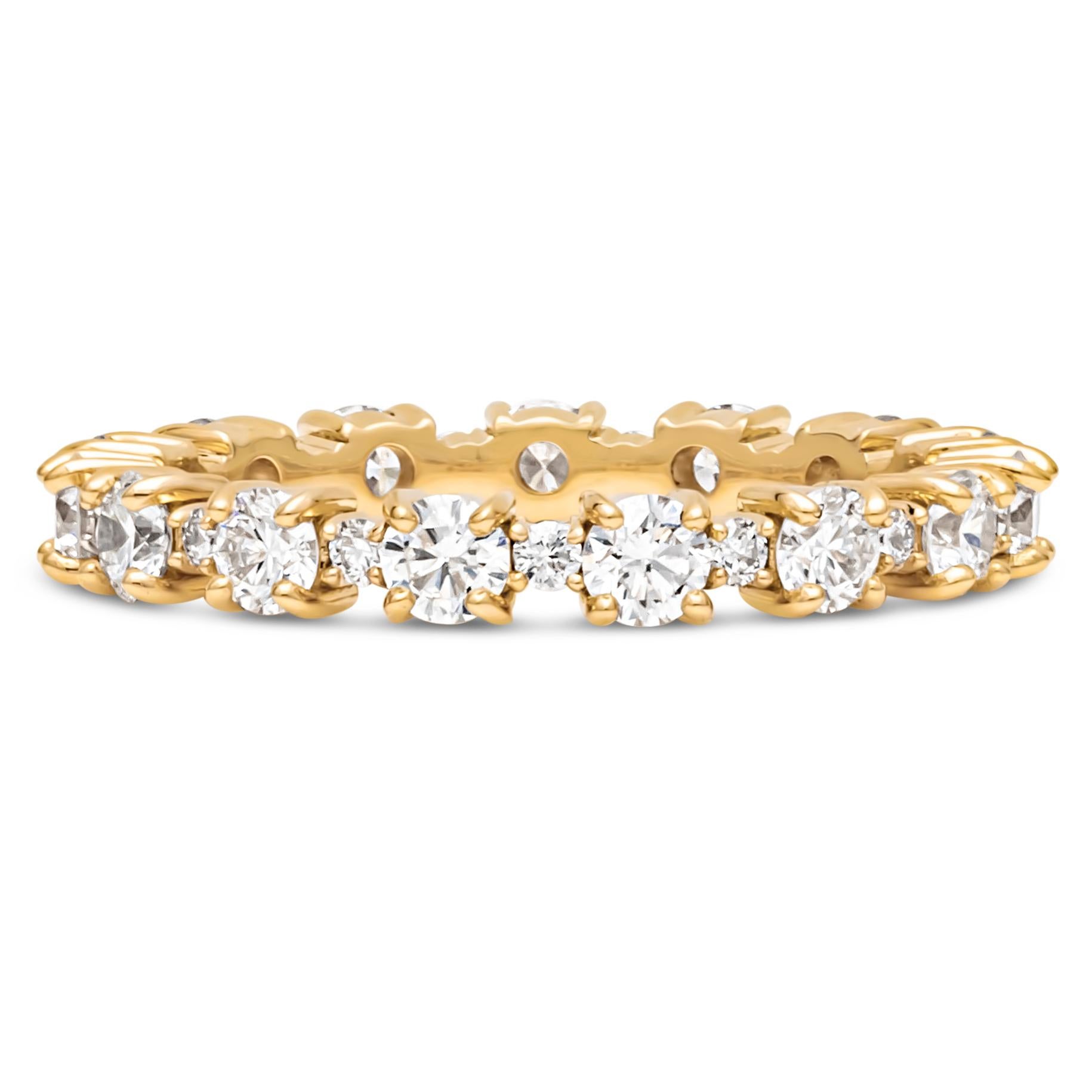 A uniquely-designed eternity wedding band showcasing a row of round brilliant diamonds elegantly spaced by smaller round melee diamonds weigh 1.34 carats total, H Color and VS in Clarity. Set in a classic four prong basket setting and Made in 18K