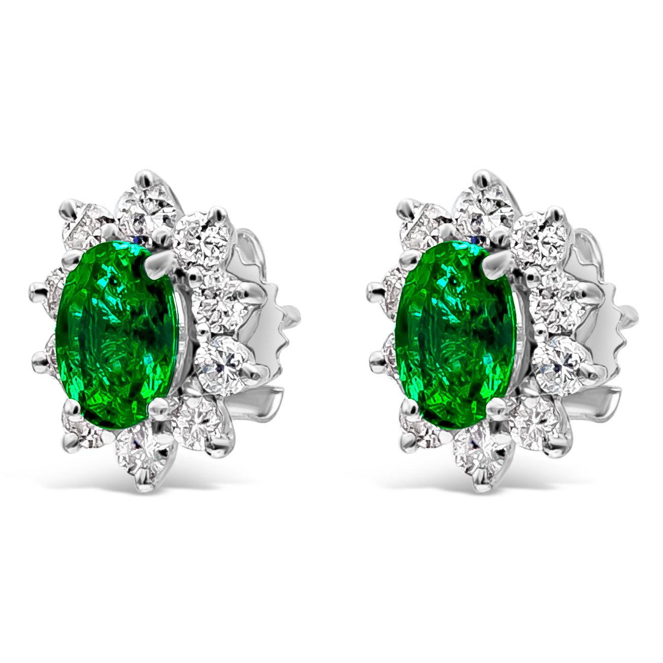 A classic pair of stud earrings in a floral-motif design showcasing oval cut green emeralds weighing 1.37 carats total. Surrounded by a single row of round brilliant diamonds weighing 0.75 carat total. Made with 18K White Gold

Style available in