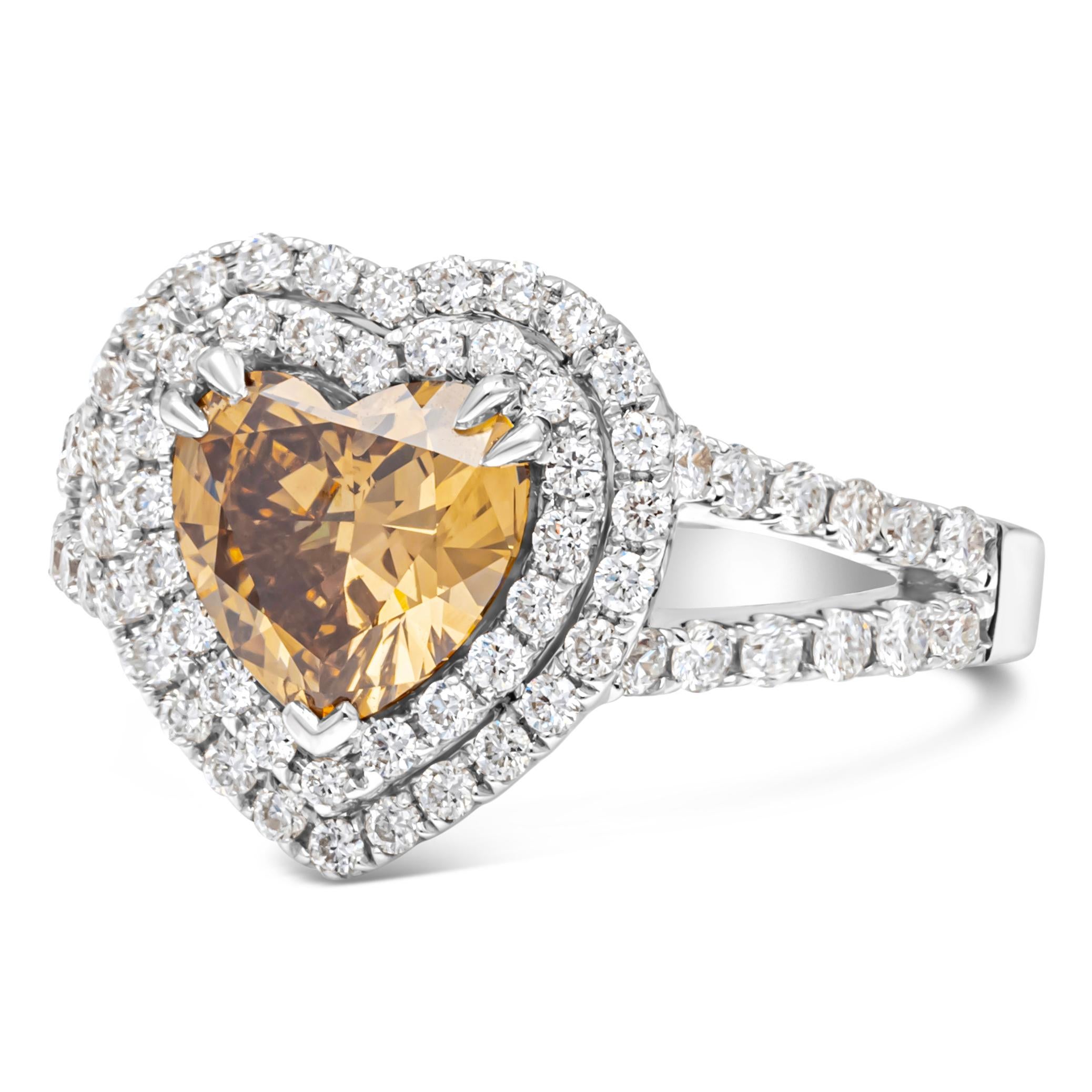 An elegant engagement ring, showcasing a 1.45 carats heart shape diamond certified by GIA as Fancy Dark Brown Yellow color and SI2 clarity, set on five prongs. Surrounded by a double halo of round brilliant cut diamonds and accented by a diamond