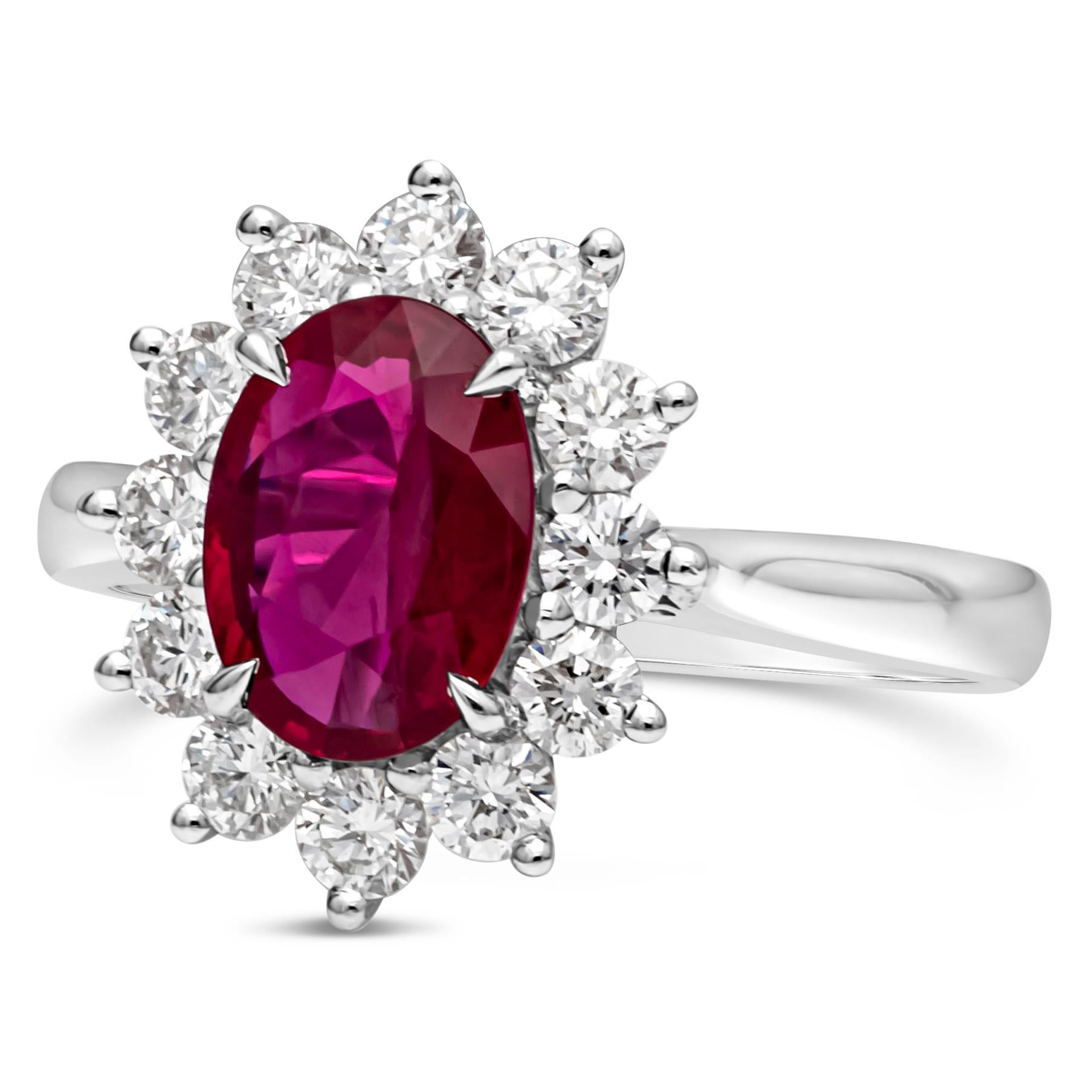This gorgeous and vibrant 1.50 carats oval cut ruby is complimented by a floral design halo set with 12 sparkling diamonds. Diamonds weigh 0.75 carats total. Made in 18K white gold composition with a comfort fit shank. Size 6.25 US and resizable