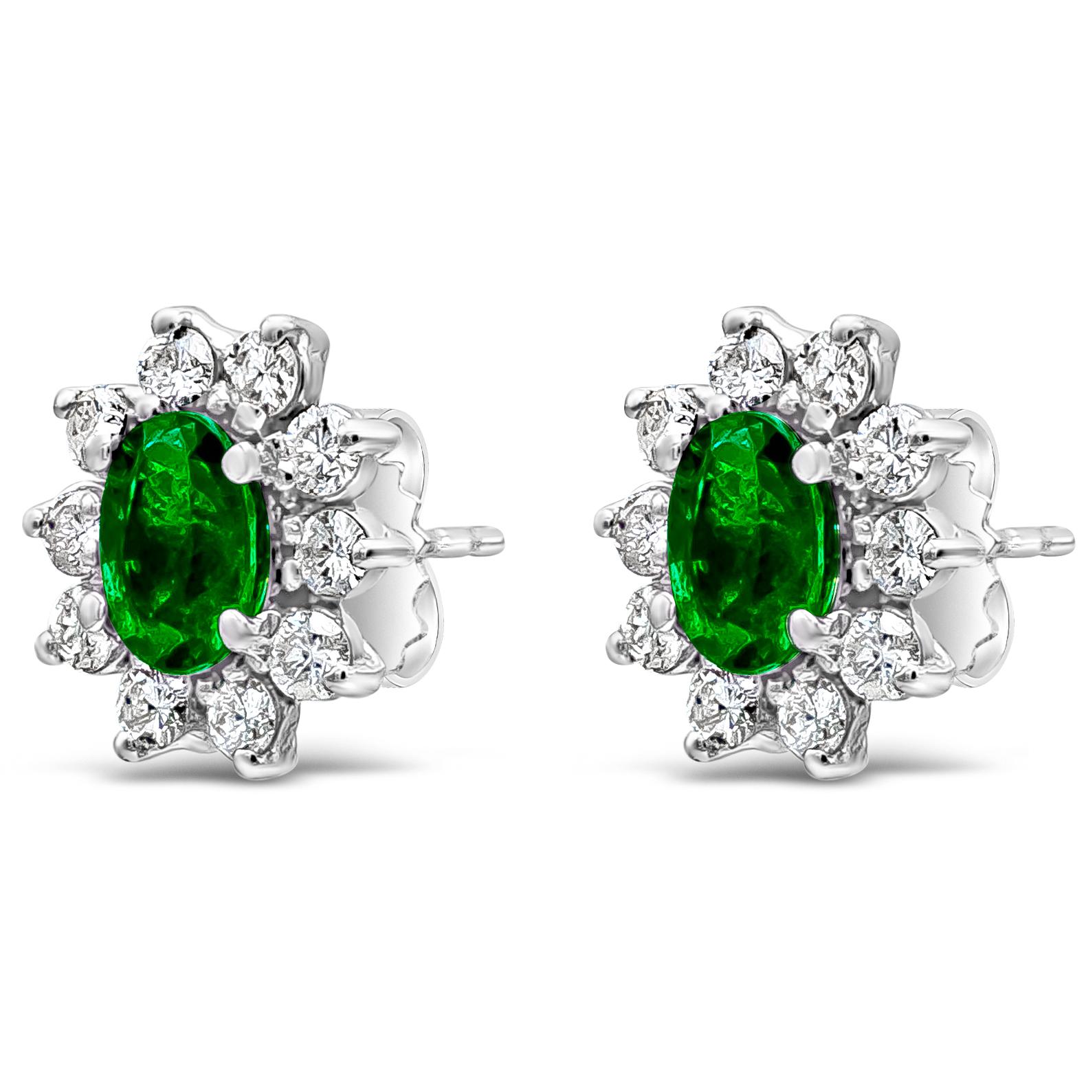 A classic pair of stud earrings in a floral-motif design showcasing oval cut green emeralds weighing 1.52 carats total. Surrounded by a single row of round brilliant diamonds weighing 1 carat total. Made with 18K White Gold

Style available in