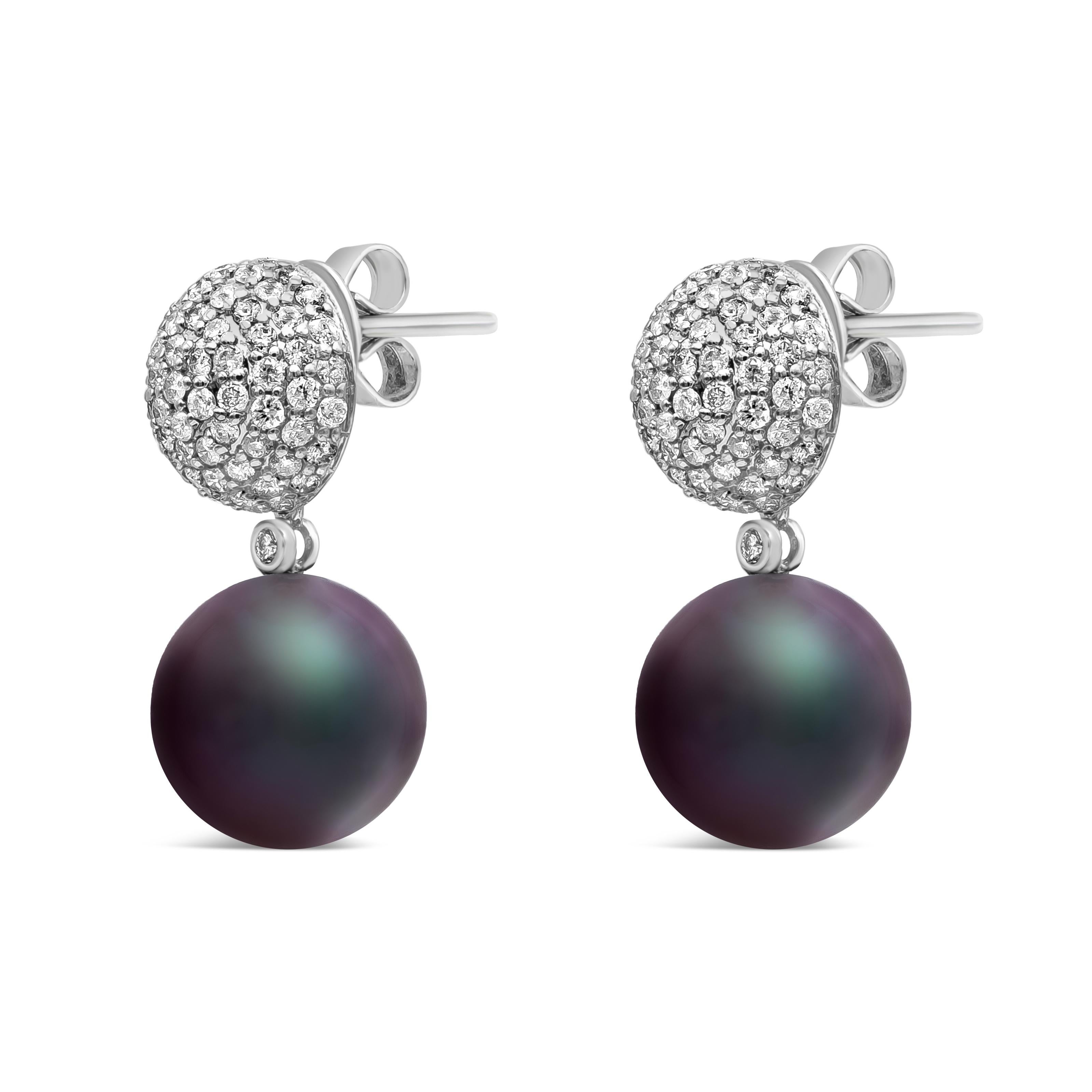 Boucles d'oreilles pendantes de style classique mettant en valeur des perles noires de Tahiti de 12-13 mm. Cette boucle d'oreille comporte 142 diamants ronds pesant au total 1,56 carats. Suspendu à une boule incrustée de diamants en or blanc 18