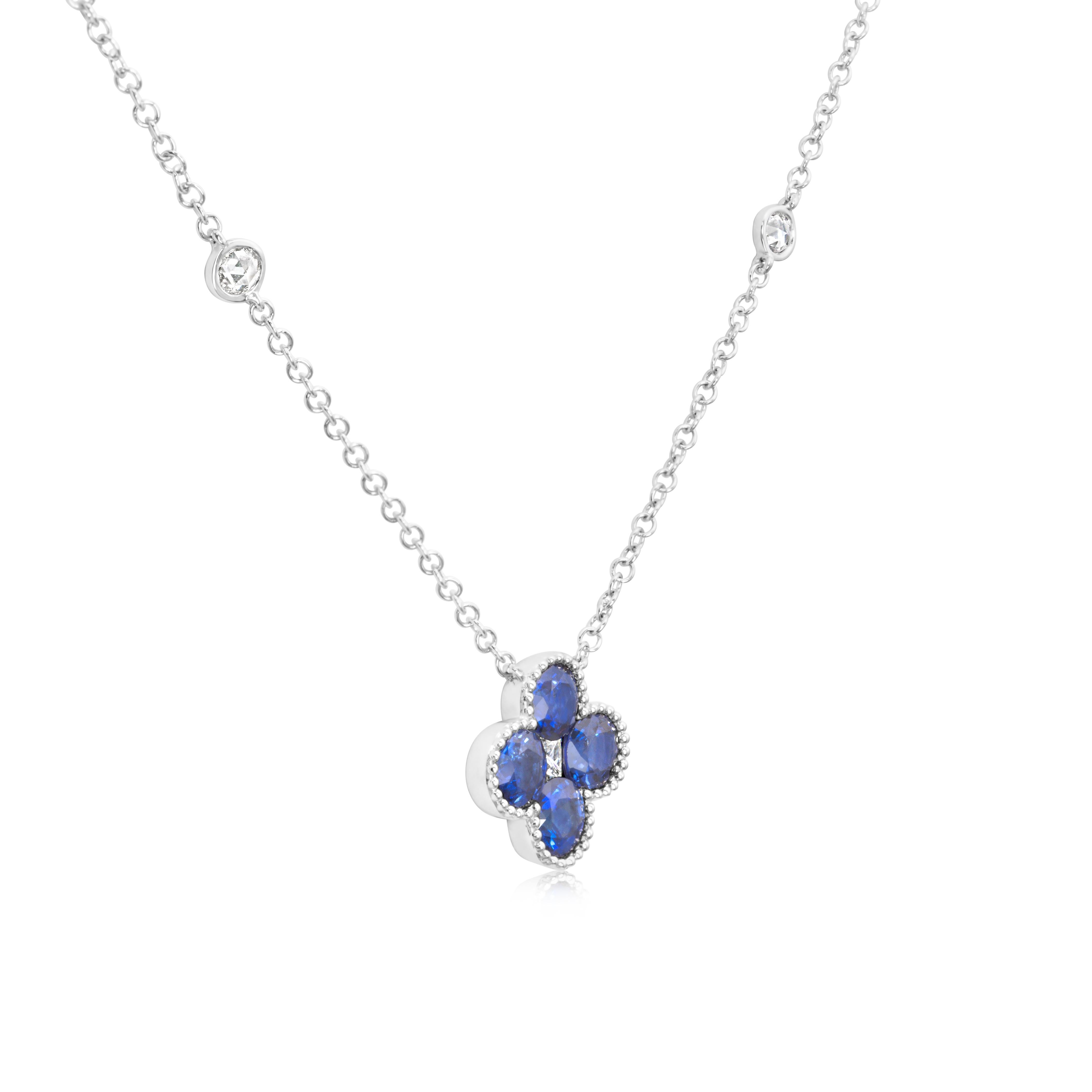 A lovely pendant necklace, featuring round cut sapphires weighing 1.40 carats total, set on a beaded bezel. Accented by a single princess cut diamond and round cut diamonds, set on a diamonds by the yard style. Accent diamonds weigh 0.23 carat