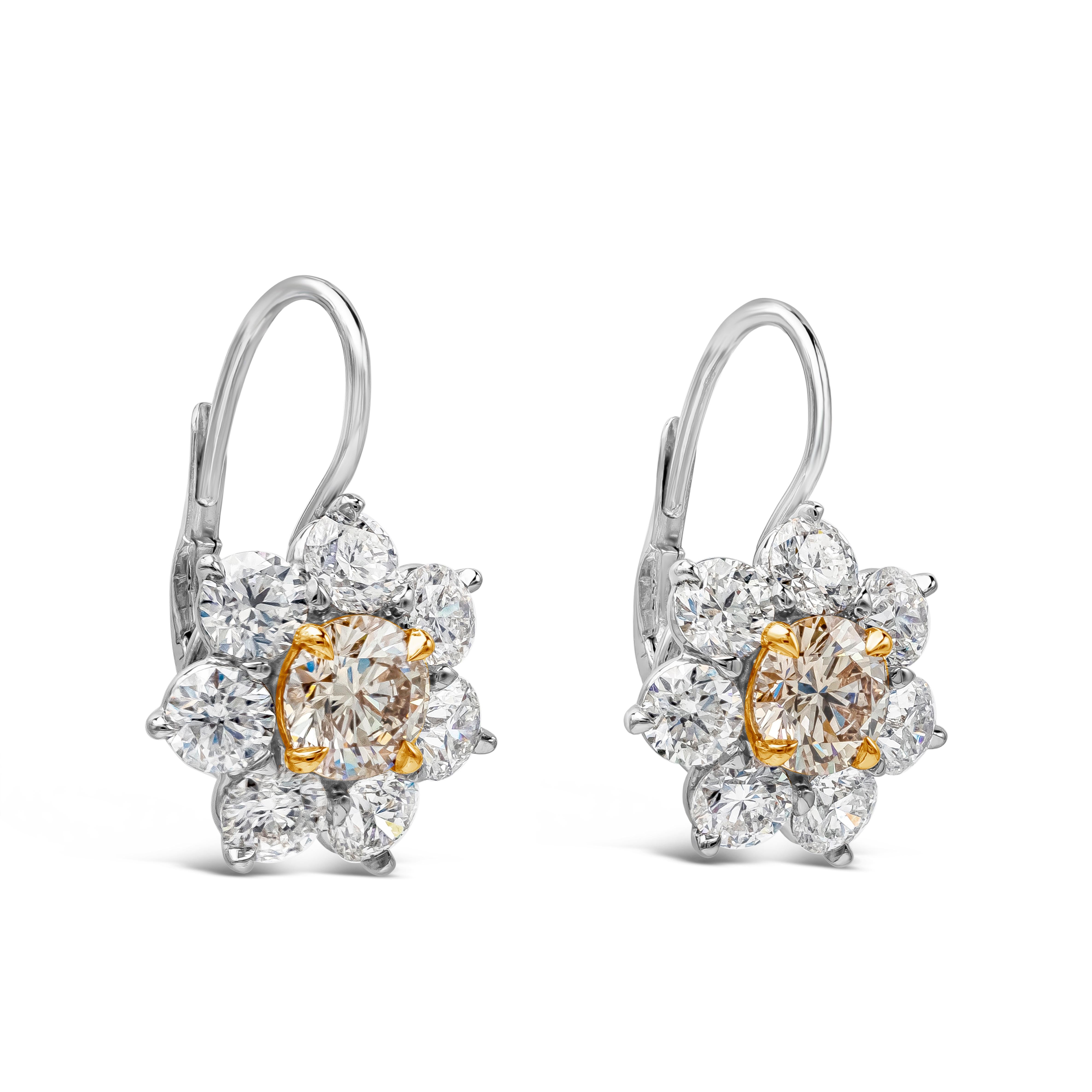 A beautiful pair of drop earrings showcasing round cut natural brown diamonds weighing 1.64 carats total, set in a 18k rose gold four prong basket setting. Surrounded by a single row of brilliant round diamonds set in a beautiful floral-motif design