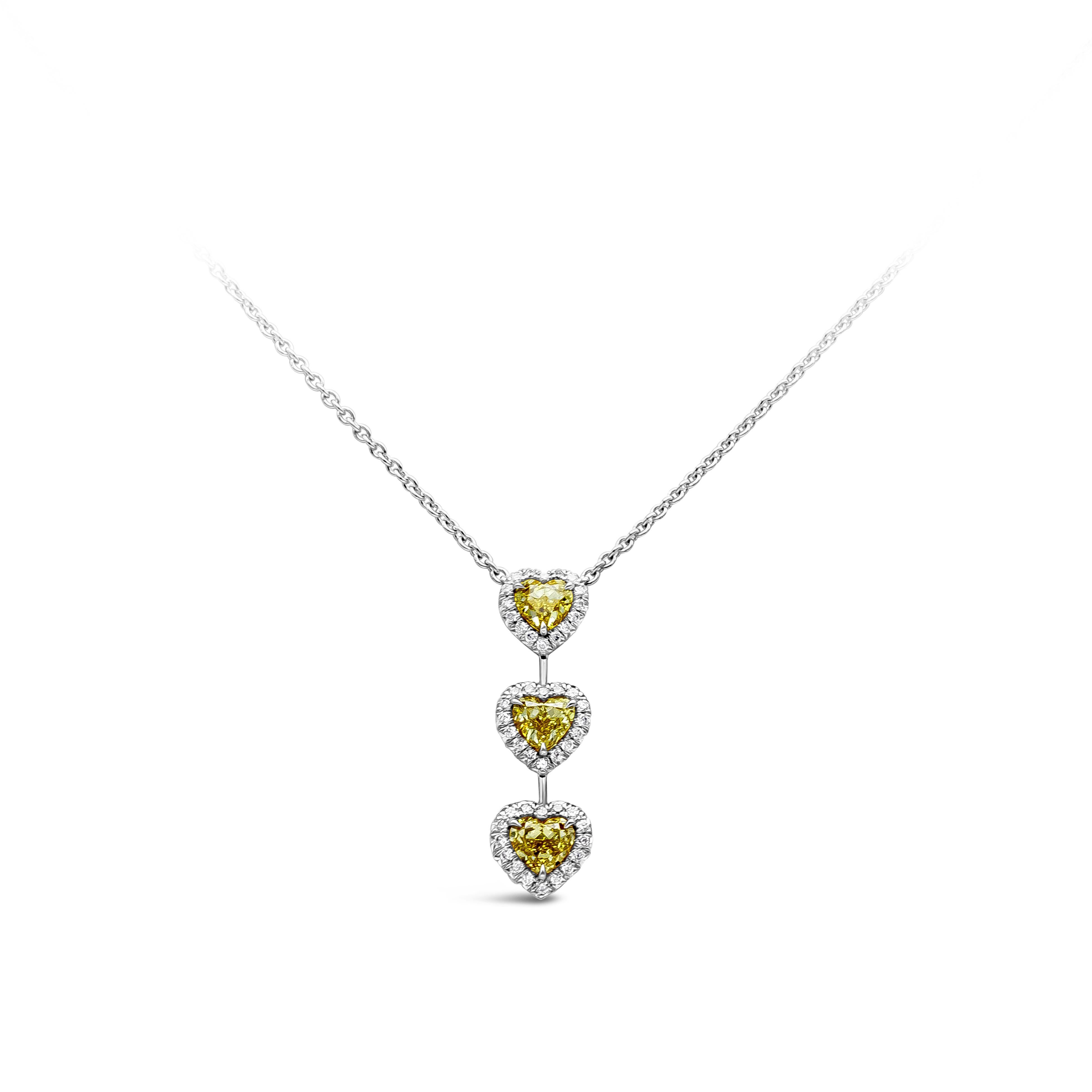 A simple but elegant diamond pendant necklace showcasing a row of three heart shape fancy intense yellow diamonds that elegantly drop on a platinum chain. Accented by 54 bright round diamonds weighing 0.33 carats total, F color and VS clarity. Fancy