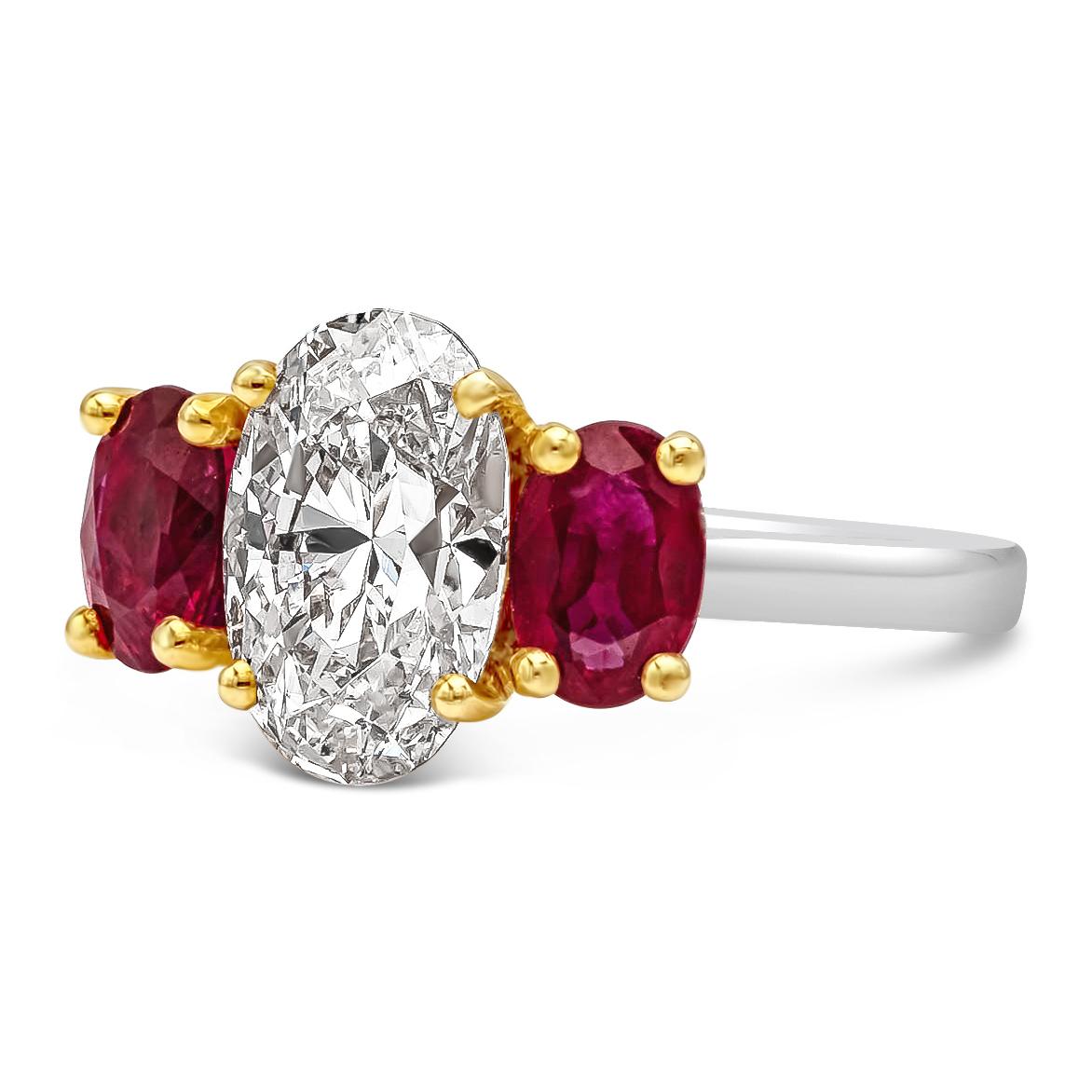 A vibrant and colorful engagement ring that features a 1.81 carats oval cut diamond elegantly flanked by oval cut rubies. The diamonds and rubies are set on a 4 prong yellow gold basket attached to a 18k white gold shank. Rubies weigh 1.41 carats