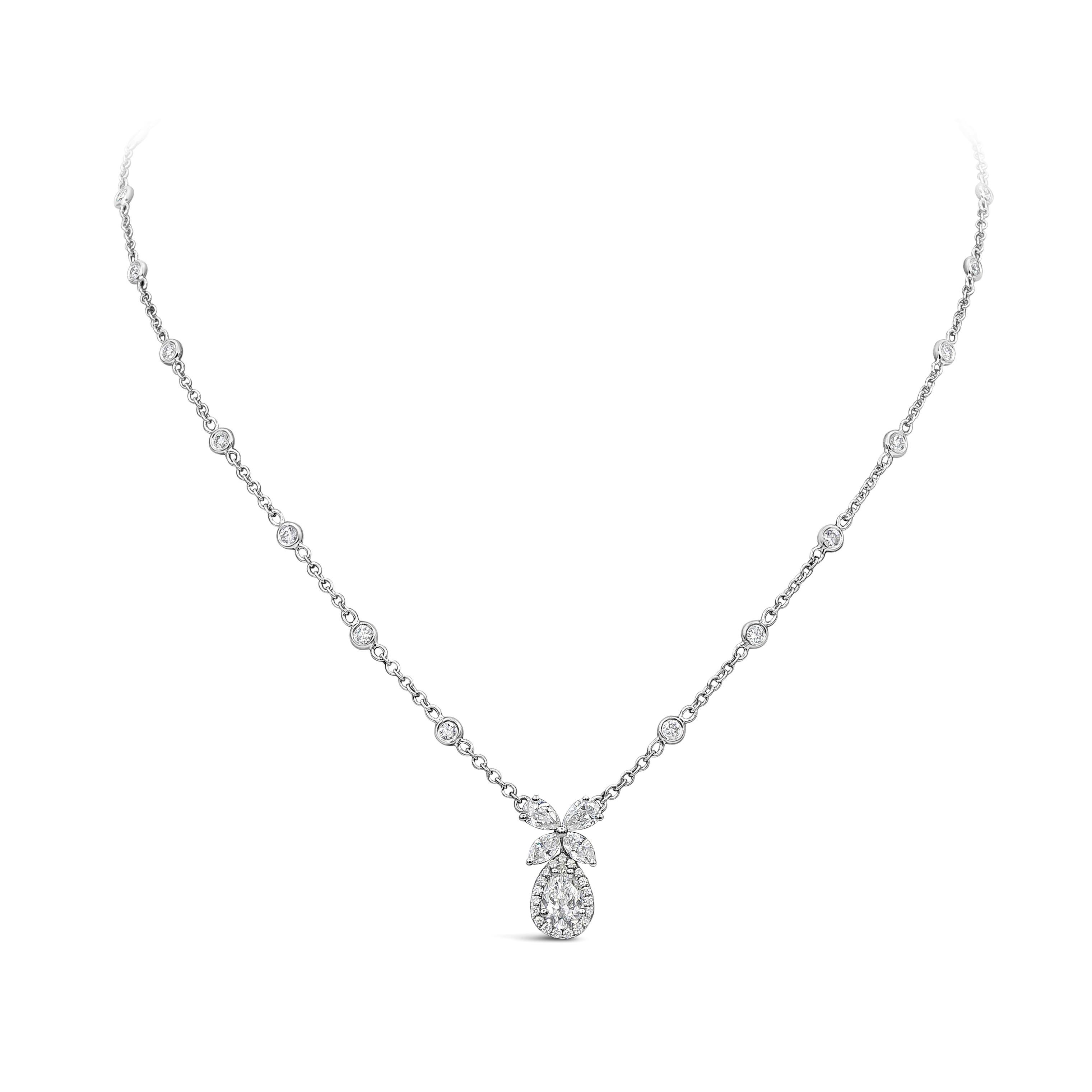 A simple and versatile pendant necklace showcasing a pear shape diamond surrounded by a single row of round brilliant diamonds in a halo design. Suspended on a flower made of pear and marquise diamonds set in an adjustable 16 inches diamonds by the