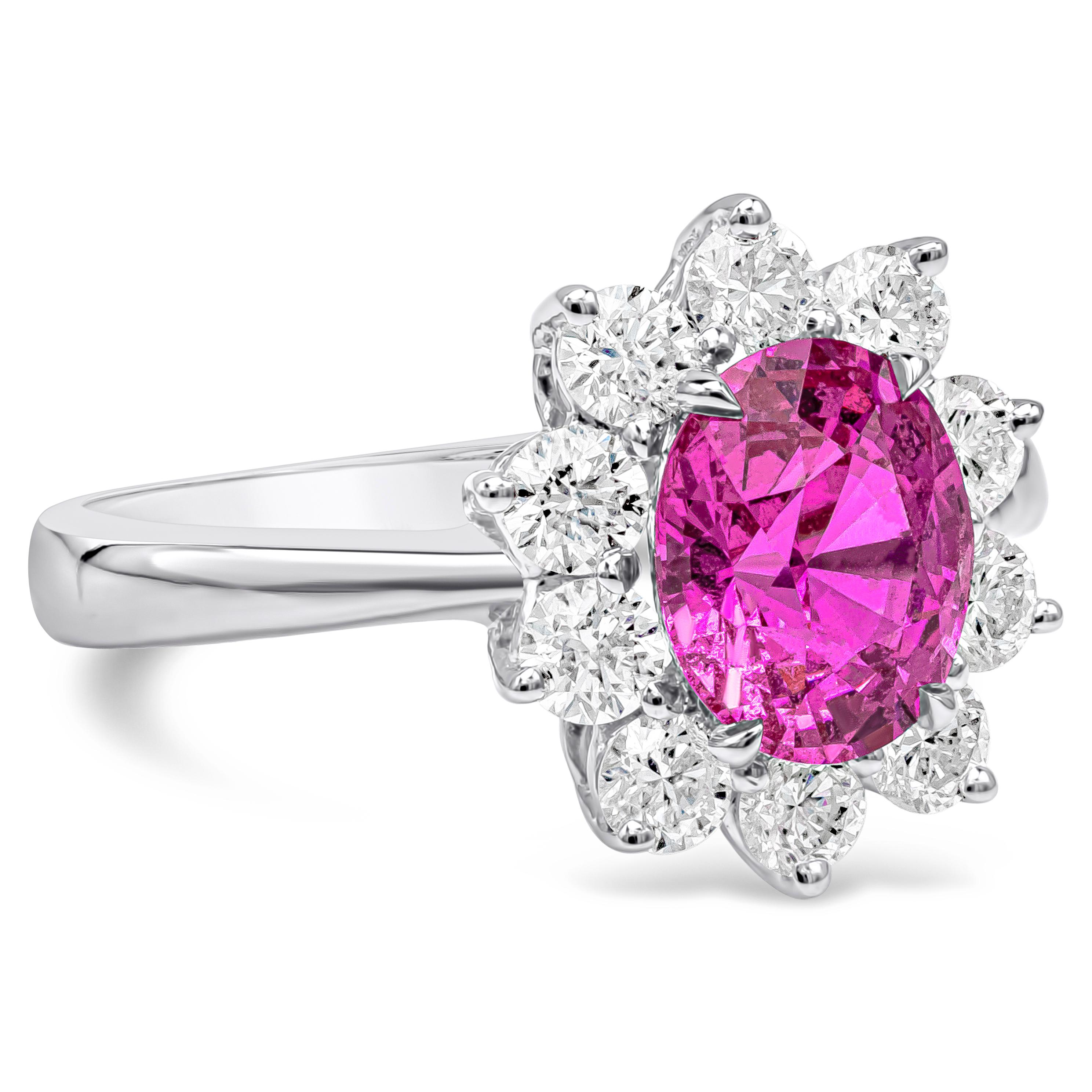 Cette bague de fiançailles en pierres précieuses met en valeur un saphir rose de taille ovale pesant au total 1,89 carat, élégamment entouré d'une rangée de diamants ronds de taille brillante dans un halo de fleurs. Les diamants pèsent 0,82 carat.