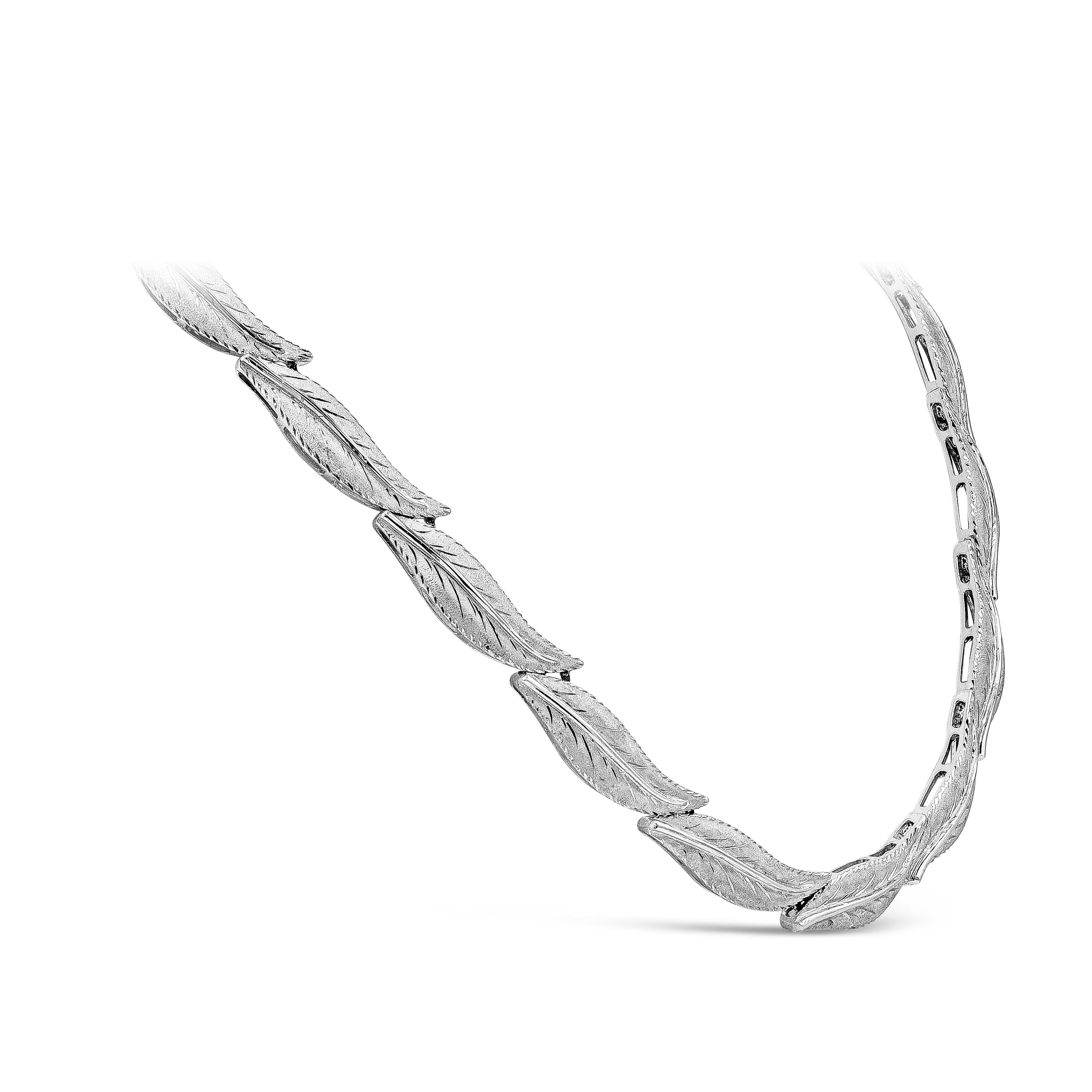 A beautiful and intricate piece of jewelry showcasing a row of interconnected leaves made in 18k white gold. Necklace weighs 51.14 grams. Has a matching white gold bracelet. 

