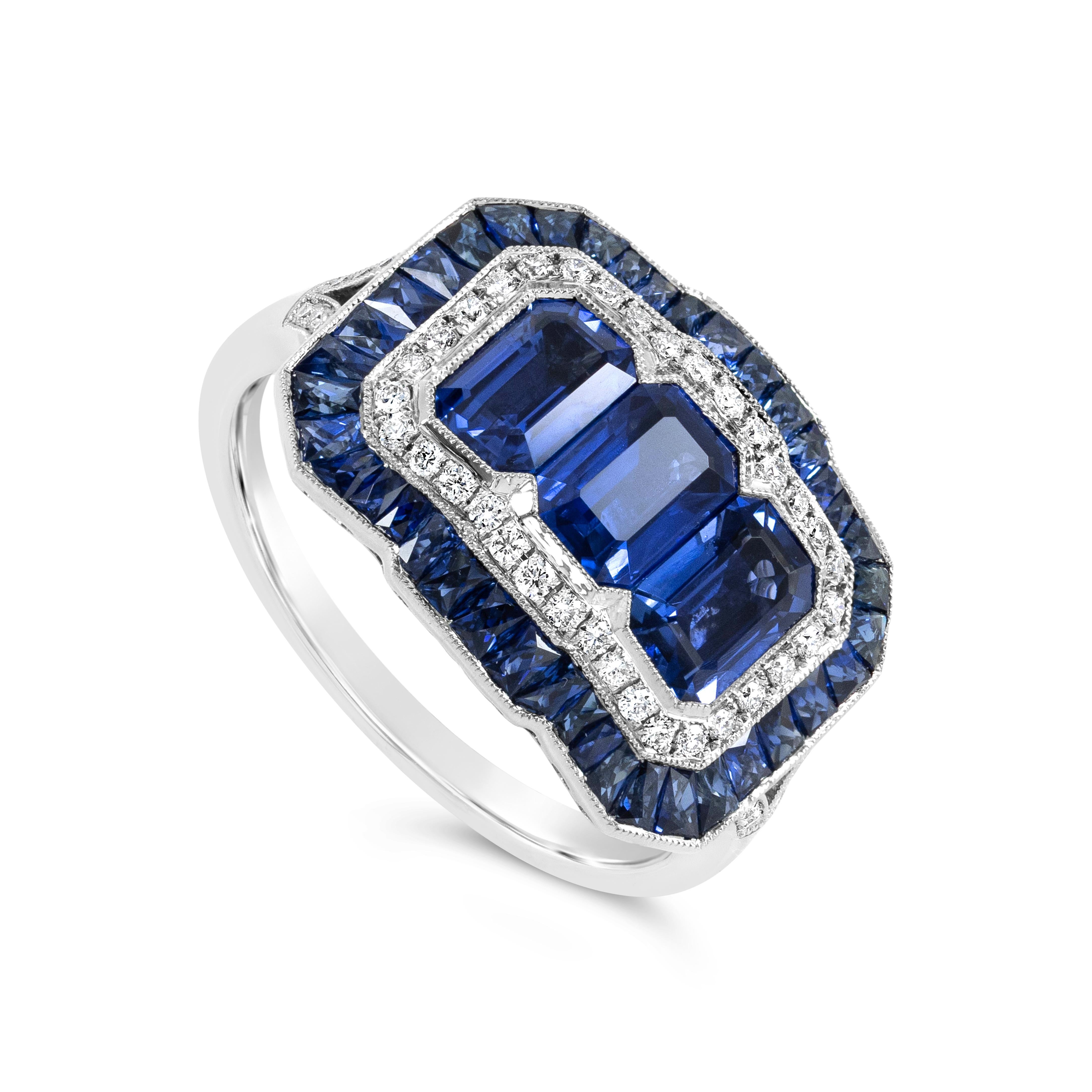 Une belle bague de mode art déco, présentant trois saphirs taille émeraude sertis d'un chaton pesant 2,01 carats au total. Entourée d'un double halo de diamants ronds pesant 0,18 carat au total et de saphirs pesant 1,12+ carat au total. Il est