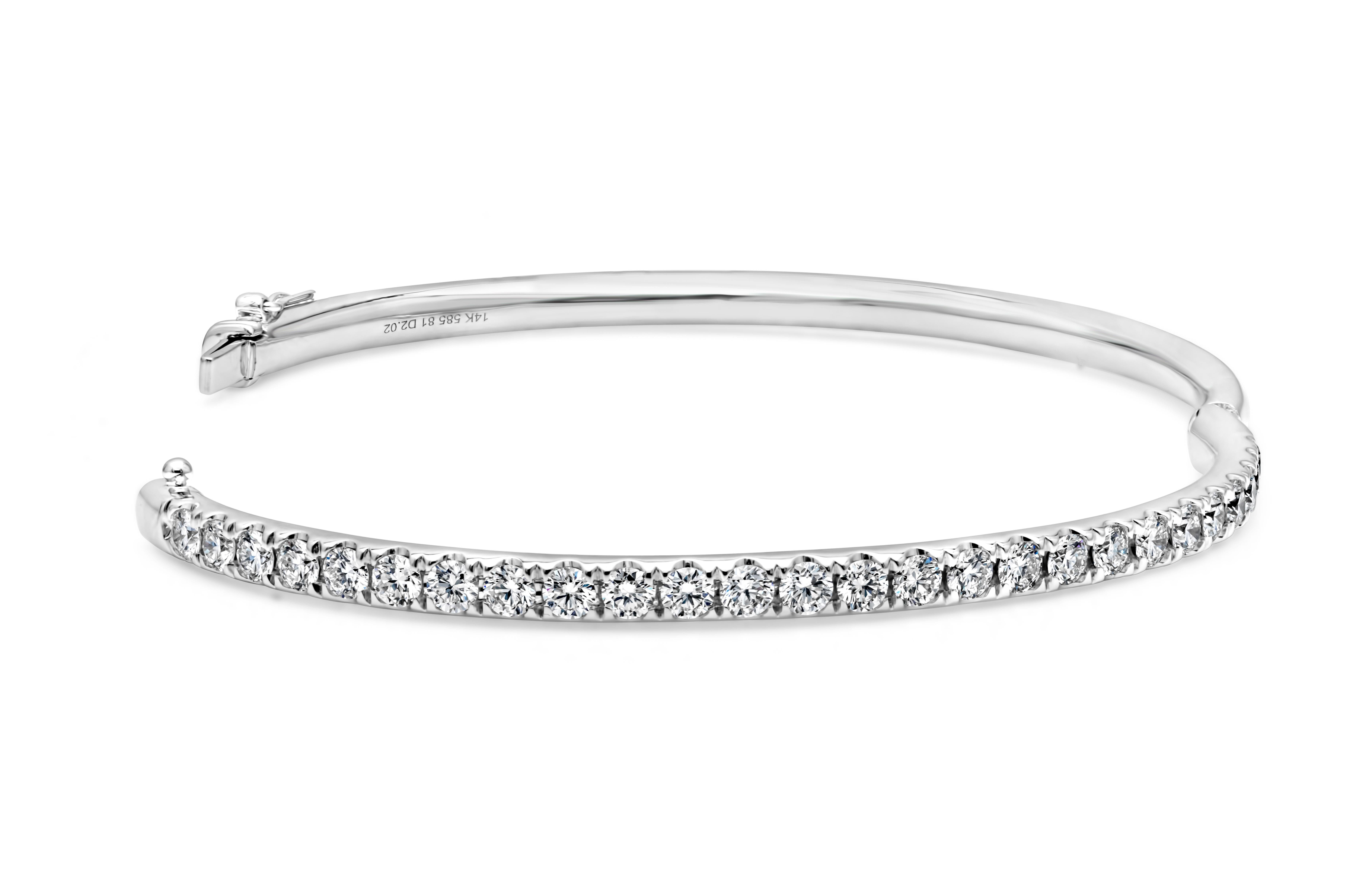 Showcasing a simple but elegant small wrist bangle bracelet set with 26 brilliant round cut diamonds weighing 2.02 carats total, F color and VS-SI1 in clarity. Has a clasp to slip and wear the bangle securely. Finely made in 14K White Gold and 6.50
