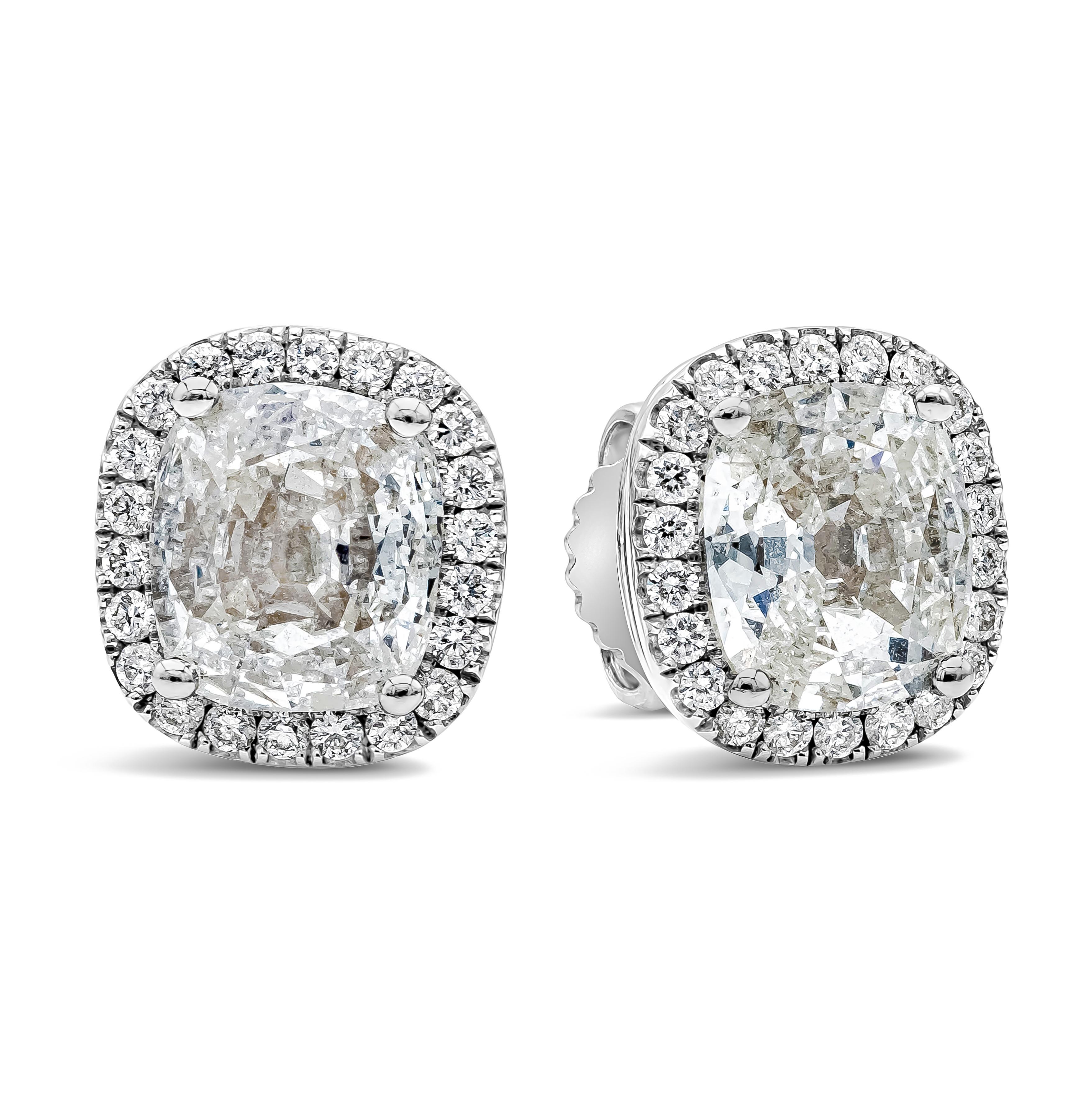 A classic pair of stud earrings showcasing a 2.03 carats cushion cut diamond certified by EGL as G-H color and VS2-SI1 in clarity, set in a classic four prong setting. Surrounded by a single row of brilliant round diamonds weighing 0.29 carats