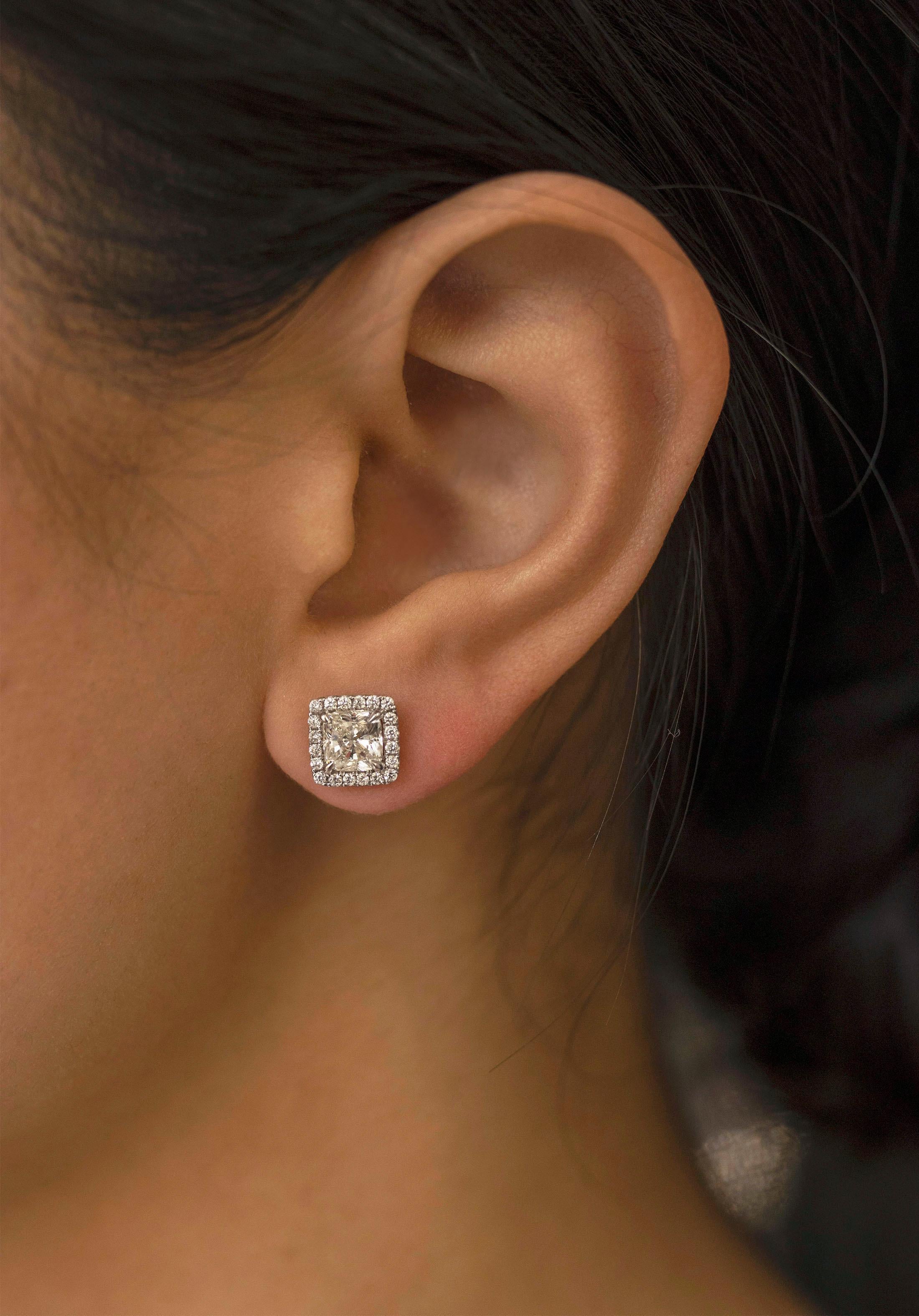 Un par de pendientes sencillos y elegantes con 2 diamantes talla cojín de 2,03 quilates en total, color J y claridad VS2. Rodeada por una única fila de 40 diamantes brillantes redondos con un peso total de 0,32 quilates. Finamente elaborada en oro