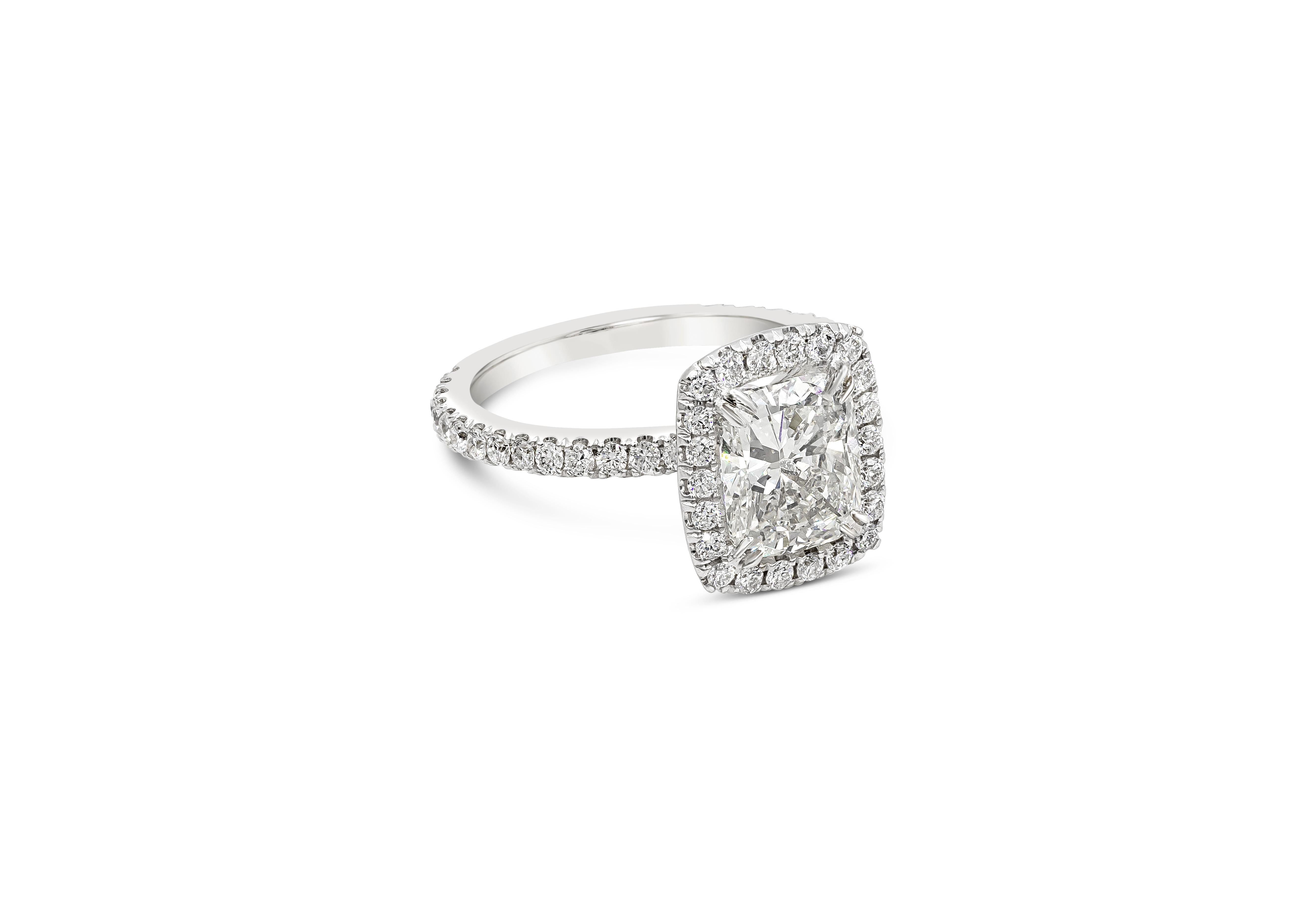 A halo engagement ring style showcasing an elongated cushion cut diamond weighing 2.20 carats, certified by EGL as F color and SI1 in clarity. Surrounded by a single row of brilliant round diamonds in an eight prong seamless halo setting. Shank is