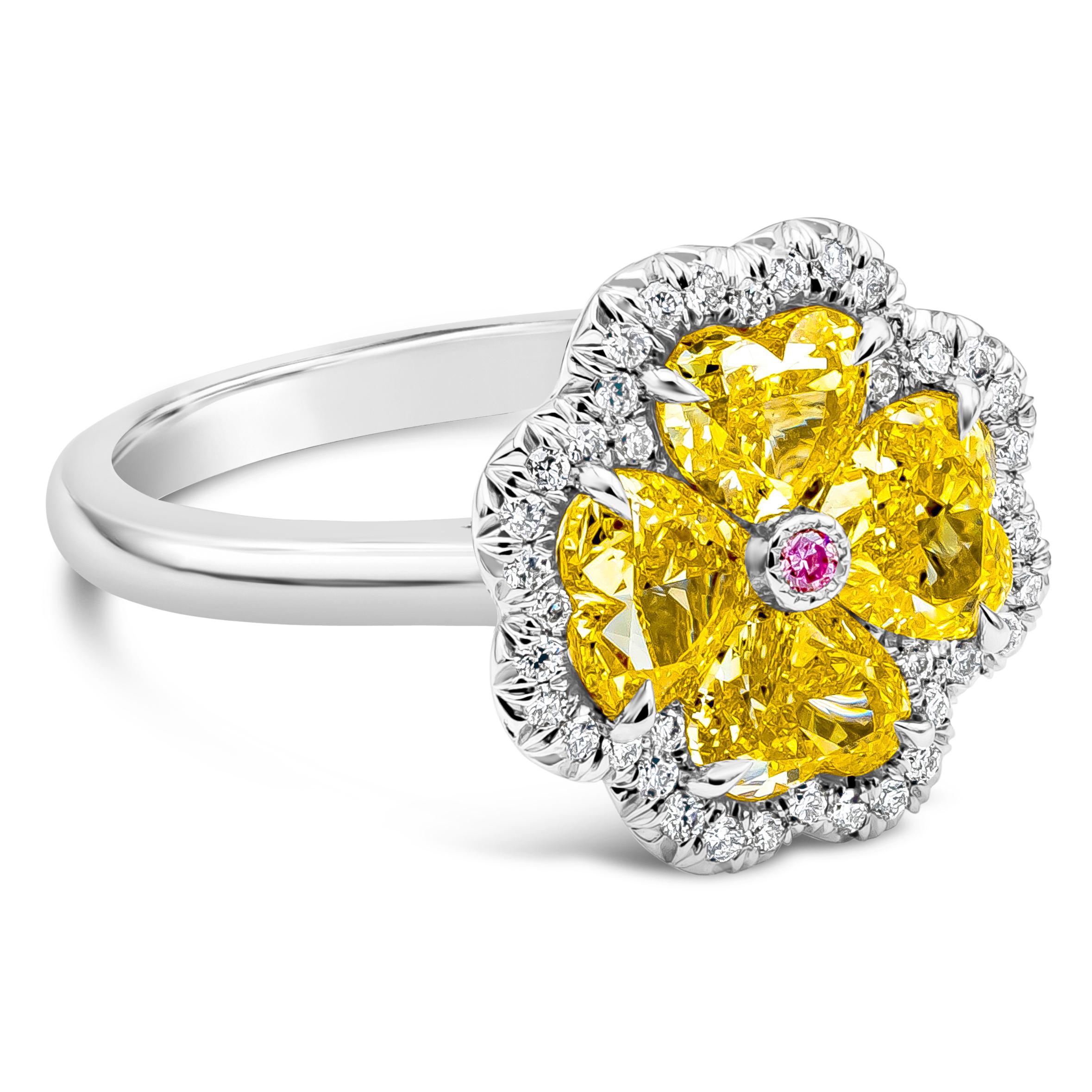 A elegant and exquisite fashion ring showcasing four heart shape diamonds weighing 2.21 carats total, Fancy Intense Yellow in color and VS+ in Clarity, Single round Fancy Intense Pink diamond accents the center set in 18K white gold. Surrounded  by