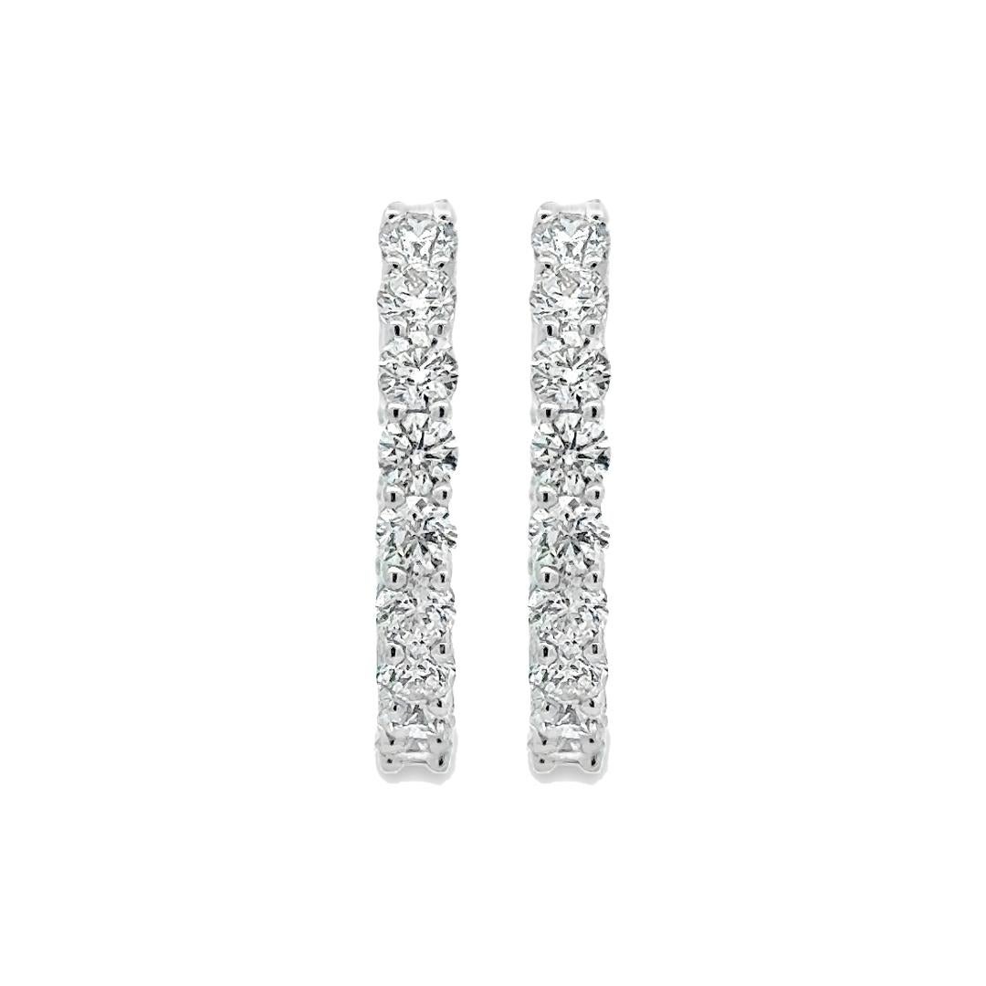 A lovely pair of hoop earrings, showcasing 30 round brilliant cut diamonds weighing 2.30 carats total, set on the front facing part of the hoop in a shared prong setting. Finely made with 18K white gold. Each earring is 20 mm in length. Perfect for