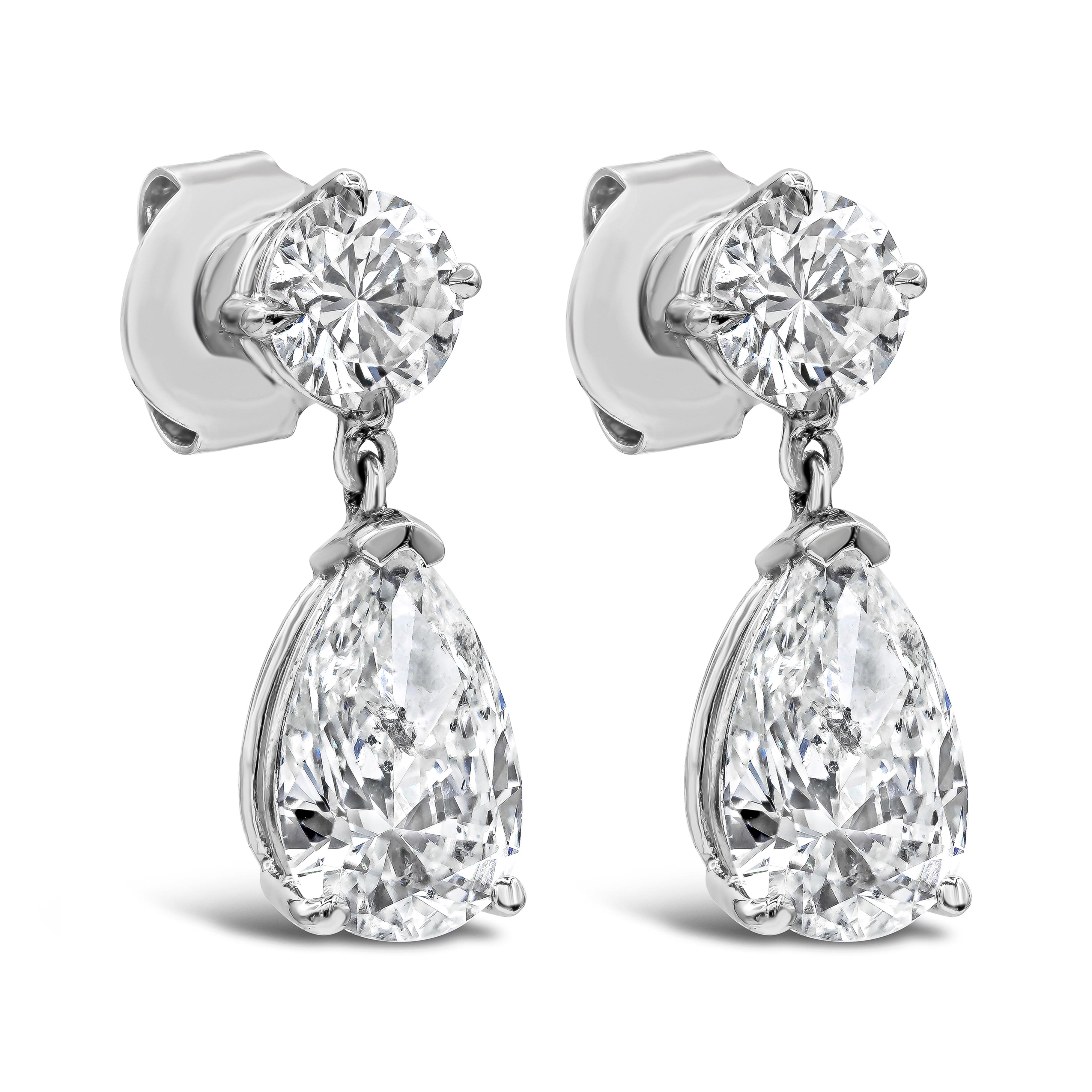 A classy pair of dangle earrings featuring a pear shape diamond drop suspended on a round brilliant diamond. Pear shape diamonds weigh 2.31 carats and are approximately D color, I1 clarity. Round diamonds weigh 0.97 carats total. Made in 14k white